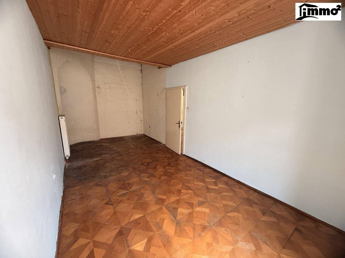 Gemütlicher Raum mit Holzdecke und Fischgrätparkett, ideal als Schlafzimmer.