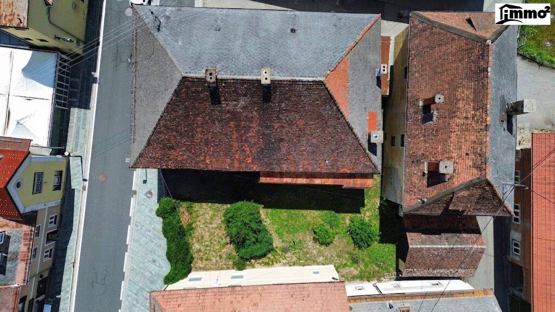 Luftaufnahme des Gebäudes mit Dach und angrenzendem Gartenbereich.