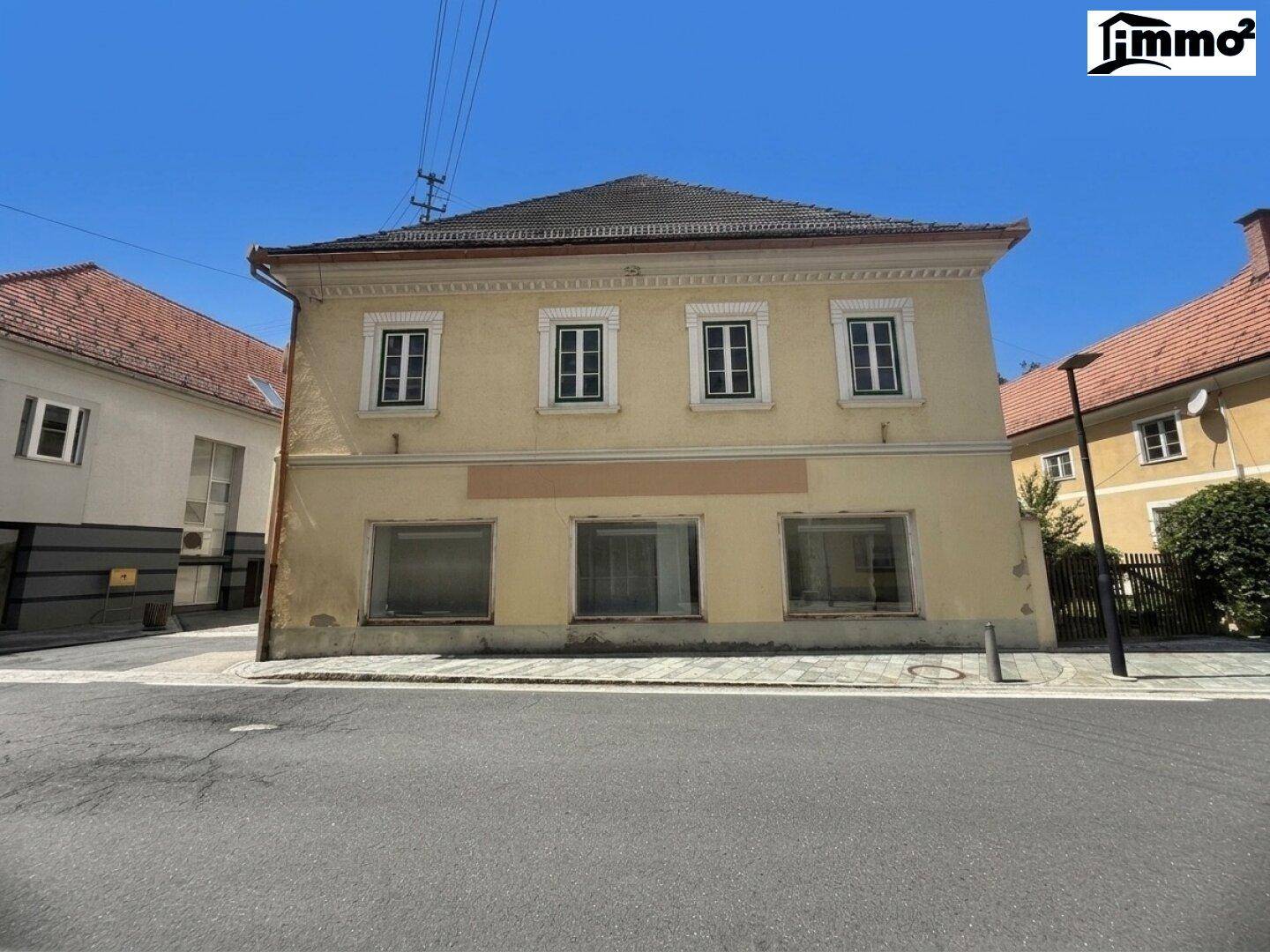 Vorderansicht des historischen Gebäudes mit gelber Fassade und traditionellen Fenstern.