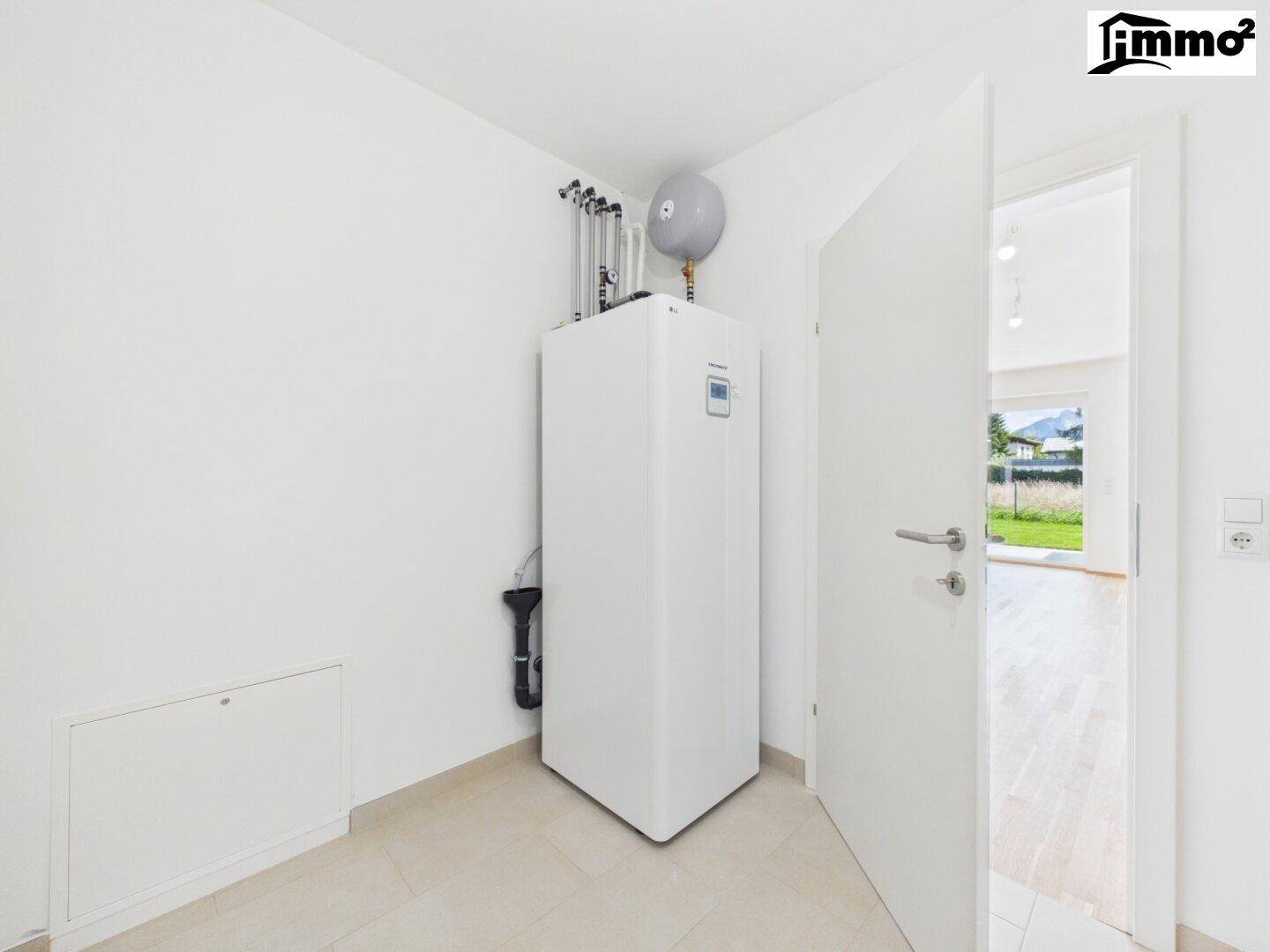 Hauswirtschaftsraum mit moderner Wärmepumpe und Warmwasserspeicher, effiziente Haustechnik.