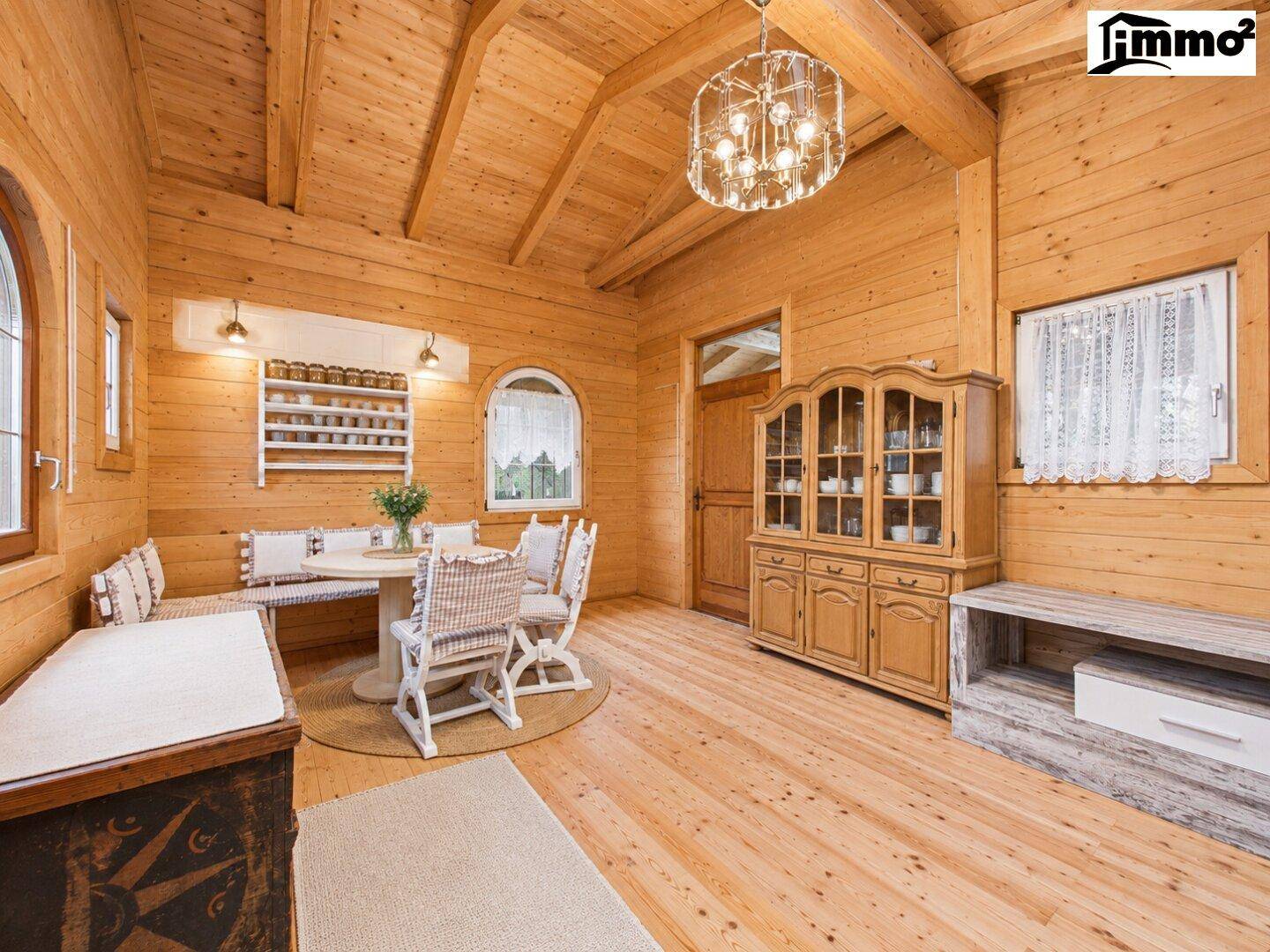 Gemütlicher Essbereich im Chalet-Stil mit Holzwänden, Holzboden und traditionellen Möbeln.