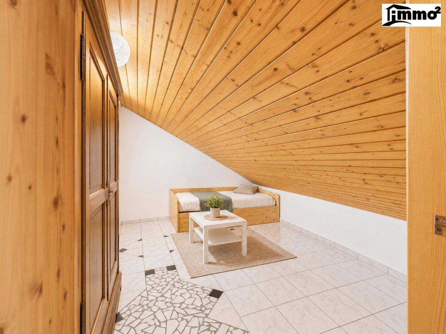 Dachgeschosszimmer mit Holzdachschräge, Einzelbett und modernen Fliesenboden.