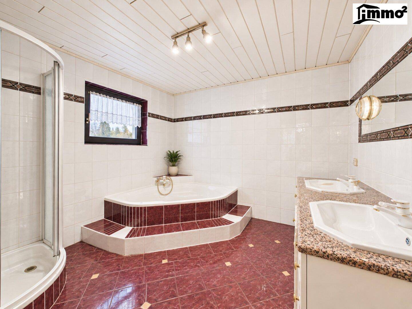 Großes Badezimmer mit Eckbadewanne, Dusche, Doppelwaschbecken und Fenster.