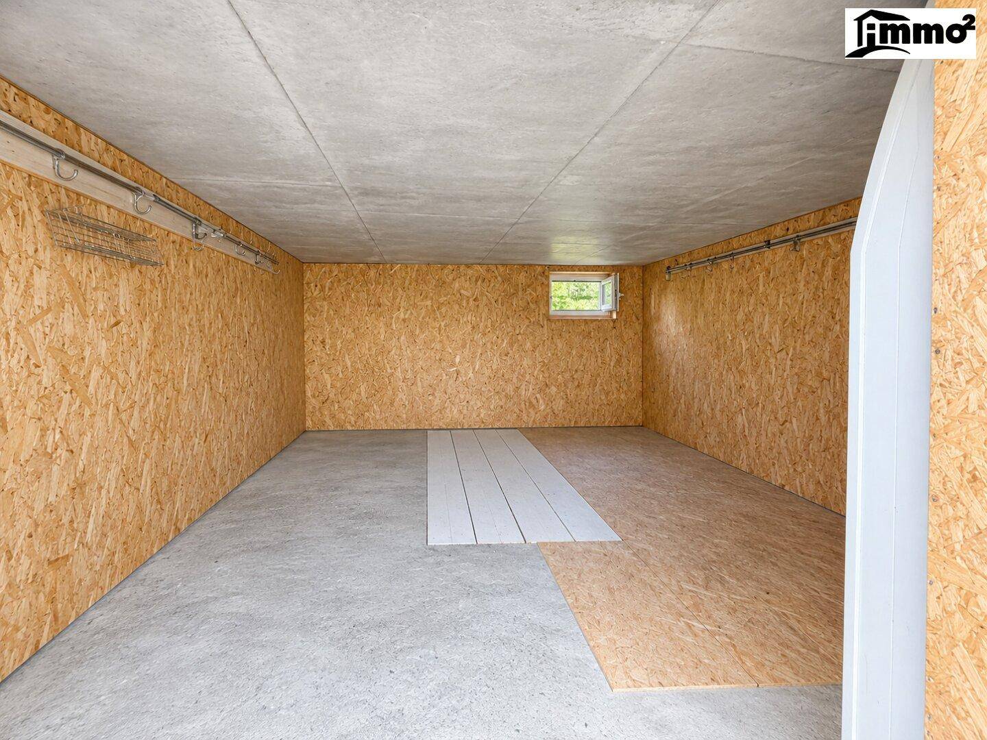 Unfertiger Kellerraum mit Betonboden und OSB-Plattenwänden, bereit für den Ausbau.