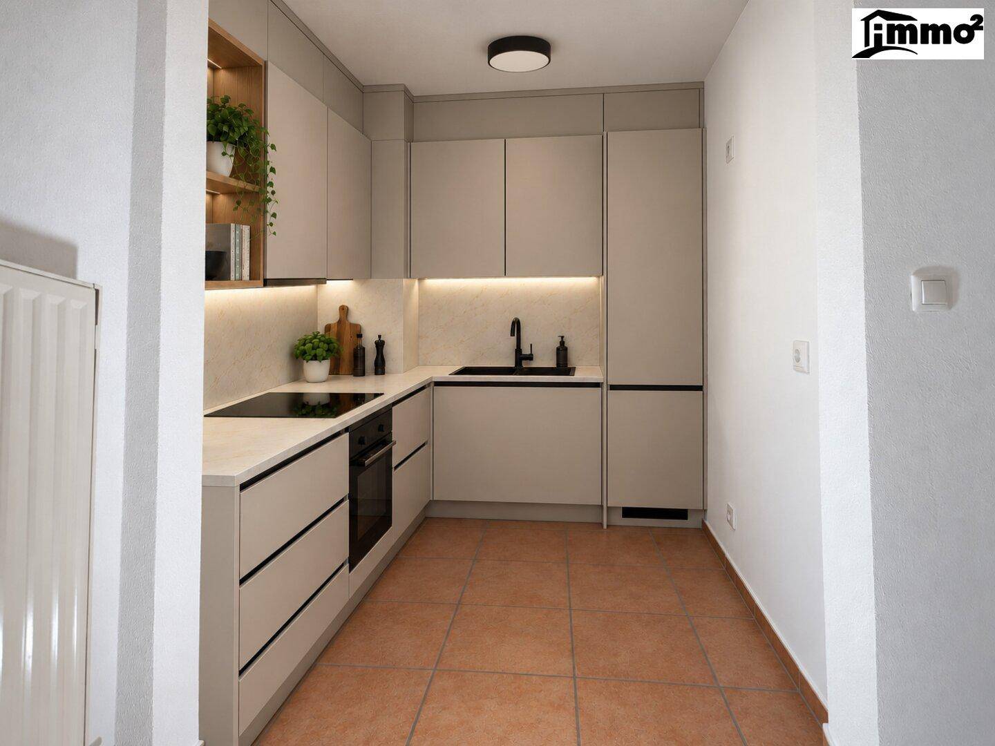 Moderne Einbauküche in hellem Beige mit integrierten Geräten und Terrakotta-Fliesenboden.