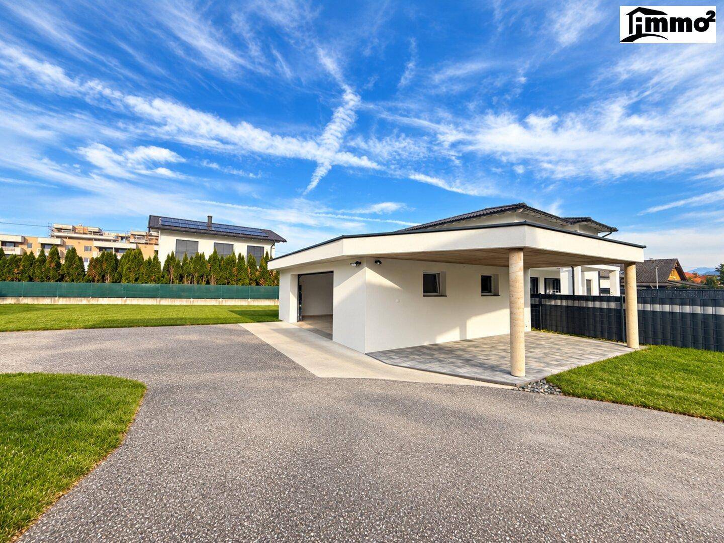 Separate Garage mit integriertem Carport und gepflasterter Zufahrt.