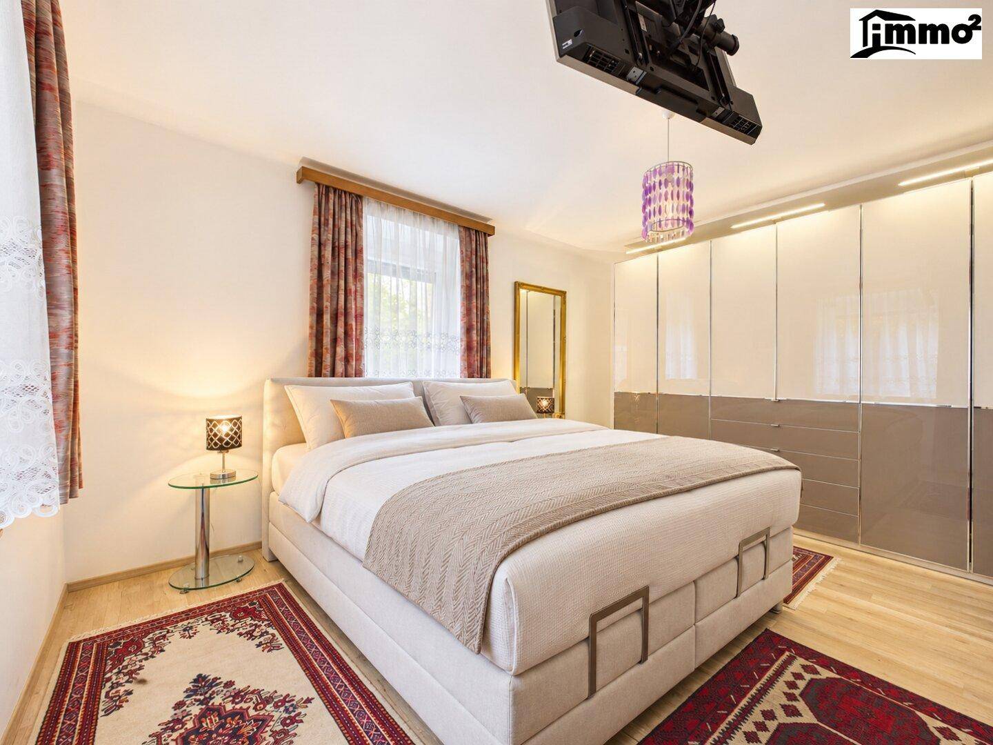 Gemütliches Schlafzimmer mit Doppelbett, Teppich und großem Kleiderschrank.