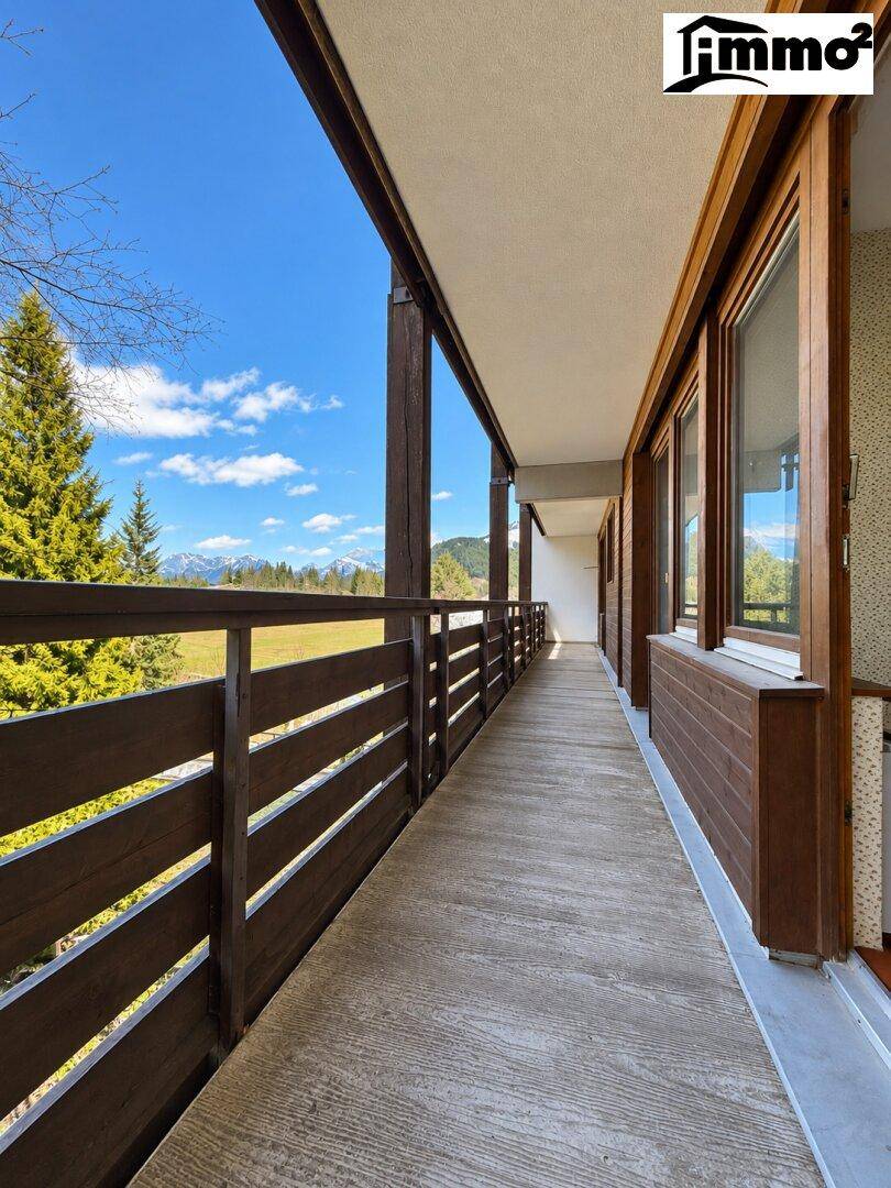 Langer Balkon mit Holzbalken und Betonboden, bietet weiten Blick auf die Landschaft.