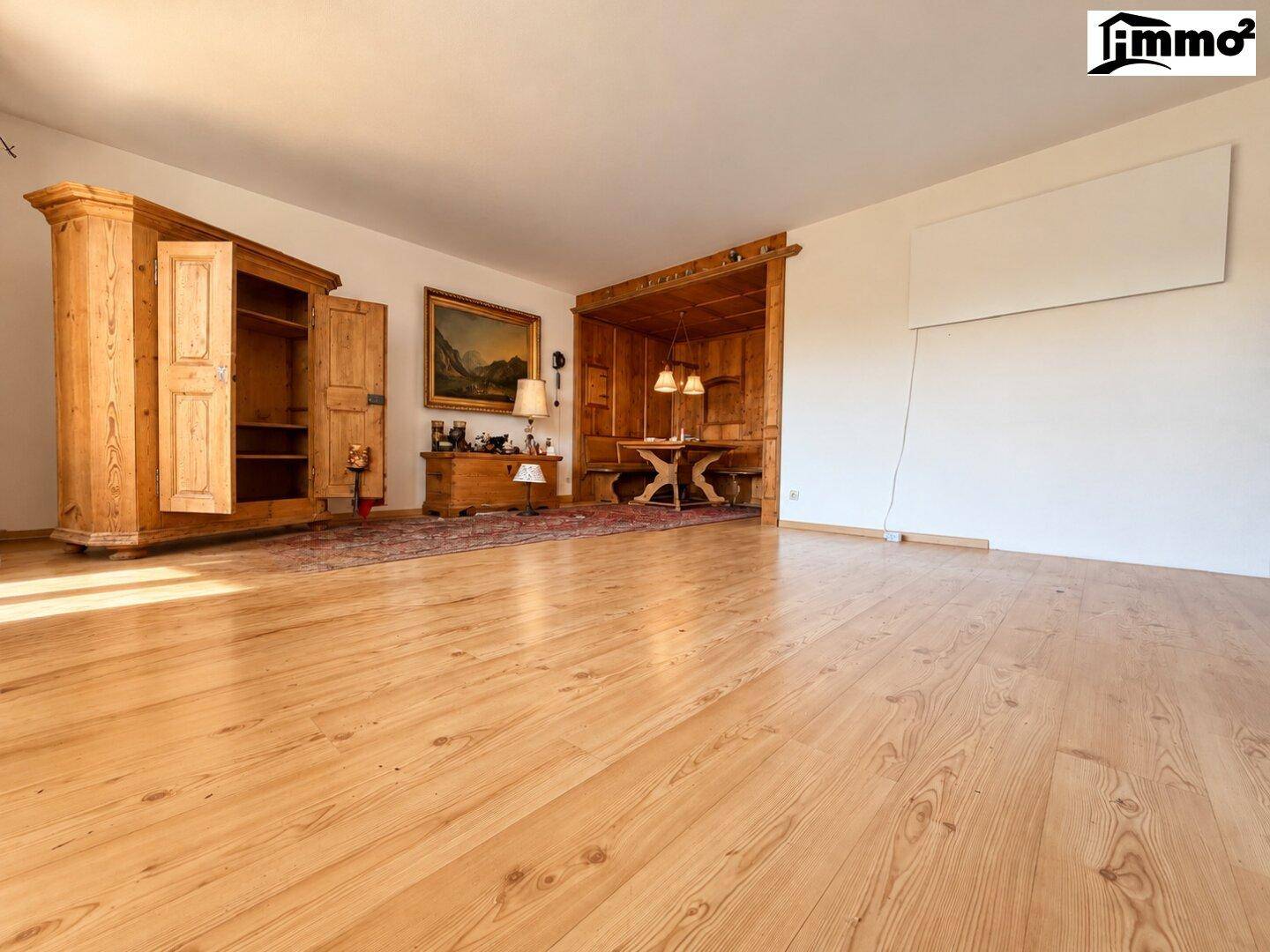 Geräumiger Wohnbereich mit Holzboden, traditionellen Holzmöbeln und einem separaten Essbereich.