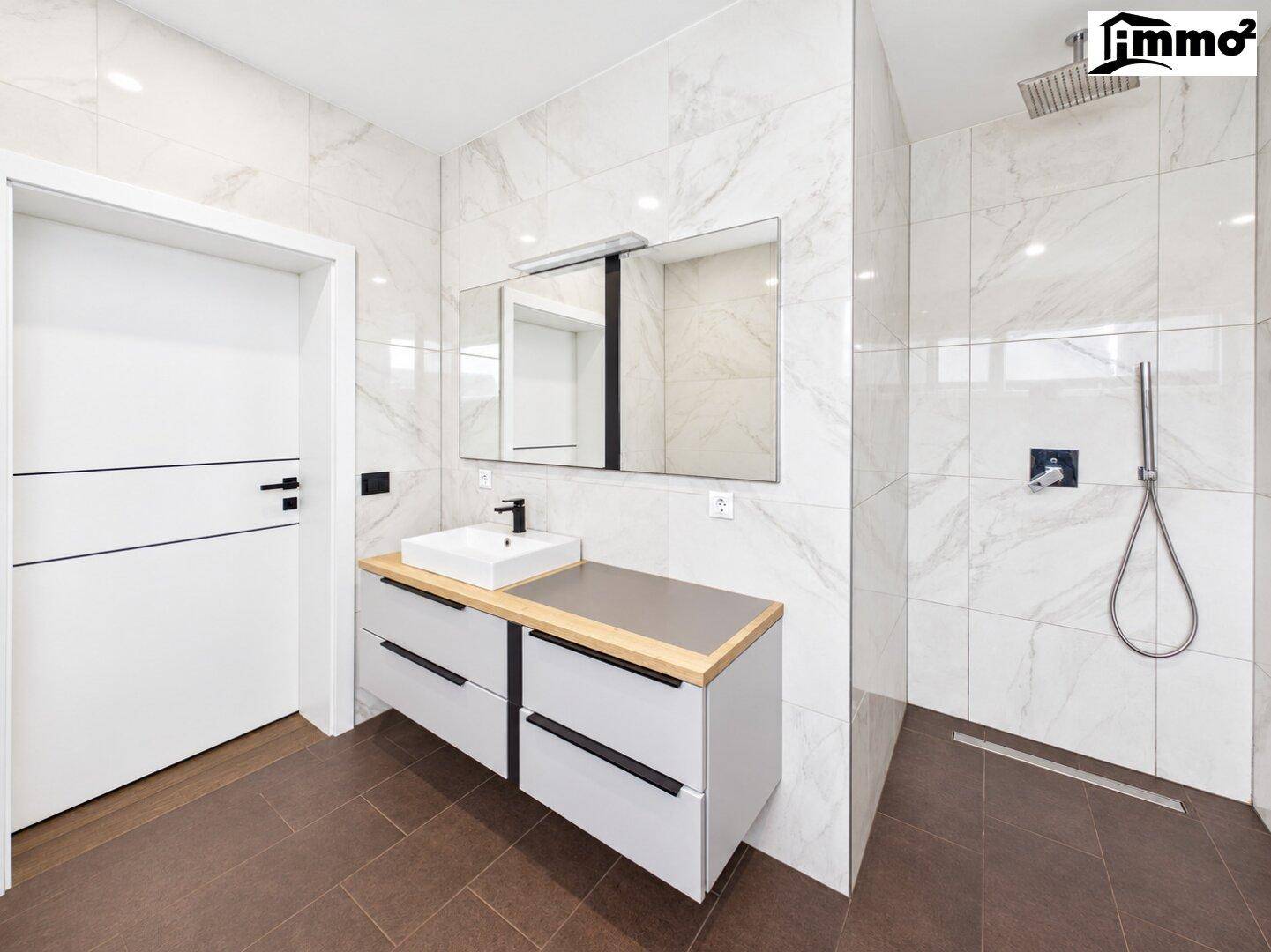 Modernes Badezimmer mit Marmorfliesen, großzügiger begehbarer Dusche und Einzelwaschbecken.