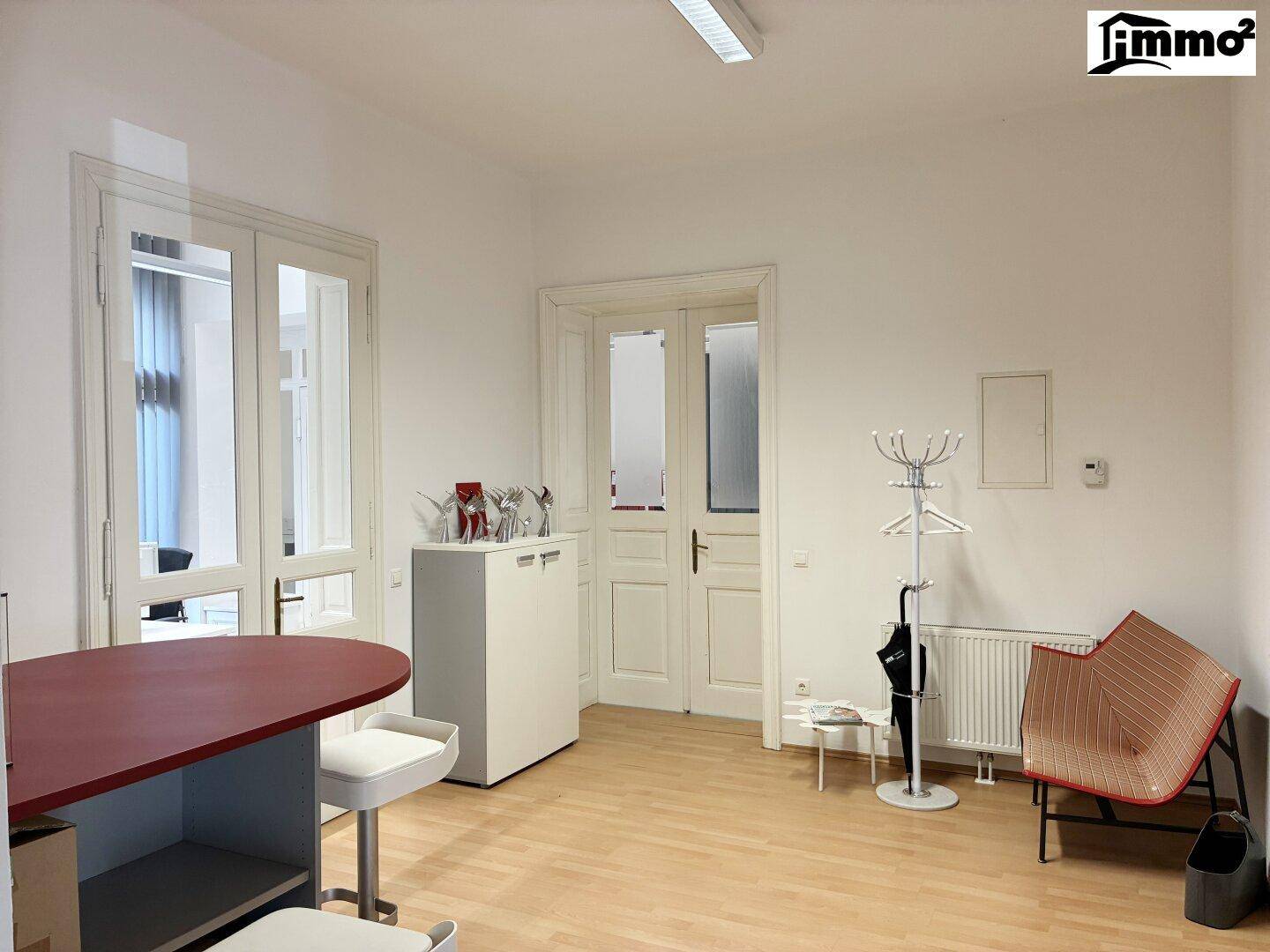 Geräumiger Wartebereich mit Garderobe, Heizkörper und Zugang zu weiteren Räumen.