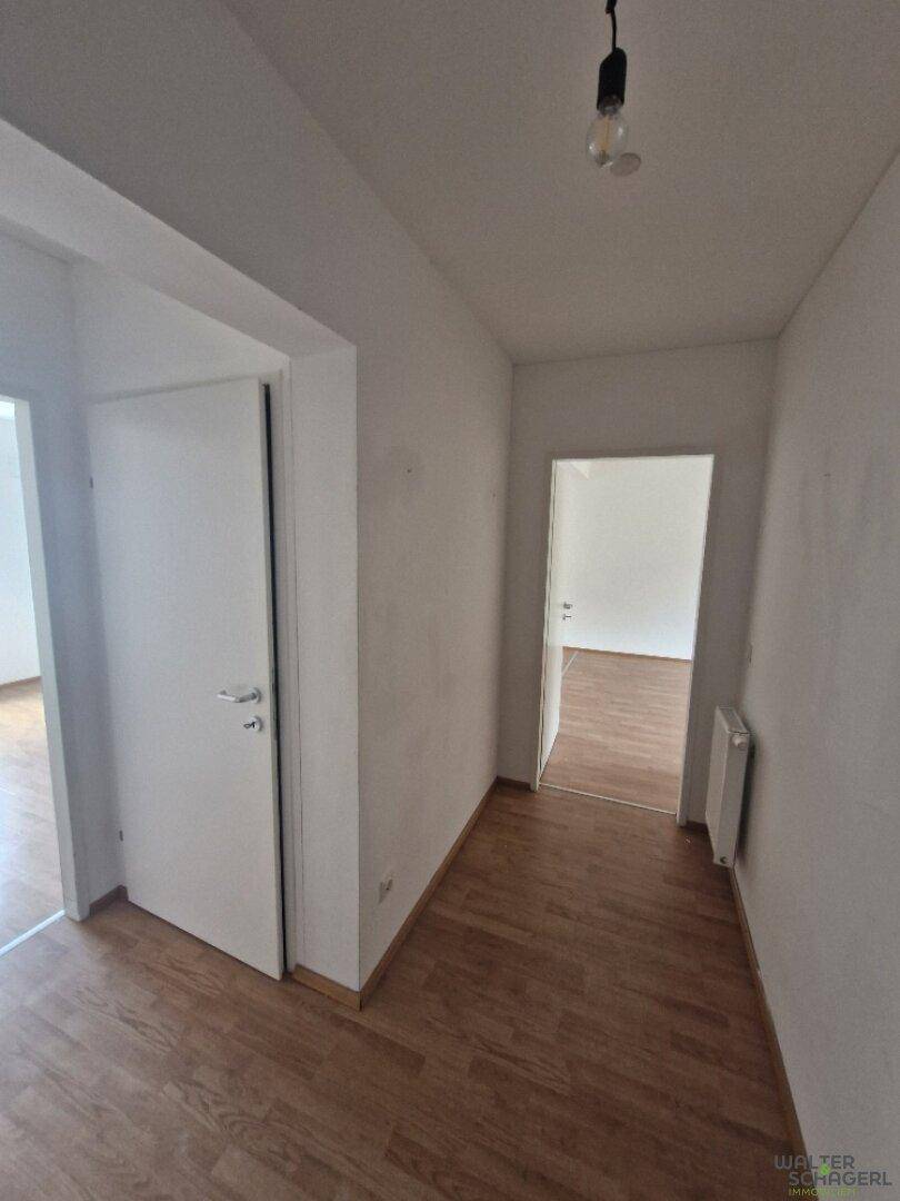 Heller Flur mit Laminatboden und Zugang zu verschiedenen Zimmern der Wohnung.