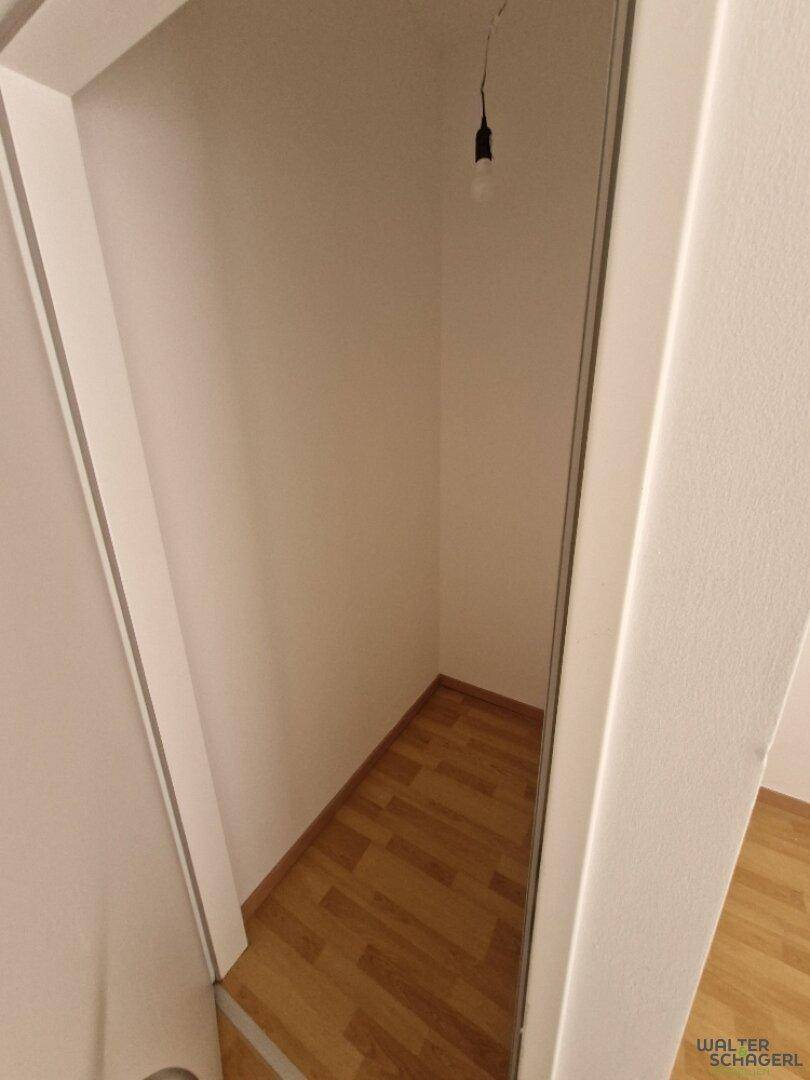 Kleiner, leerer Abstellraum mit Holzfußboden, ideal für zusätzlichen Stauraum im Haushalt.