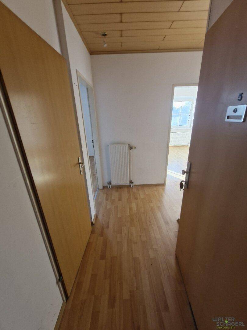 Eingangsbereich mit Holzboden und Holzdeckenverkleidung, der Zugang zu verschiedenen Zimmern ermöglicht.