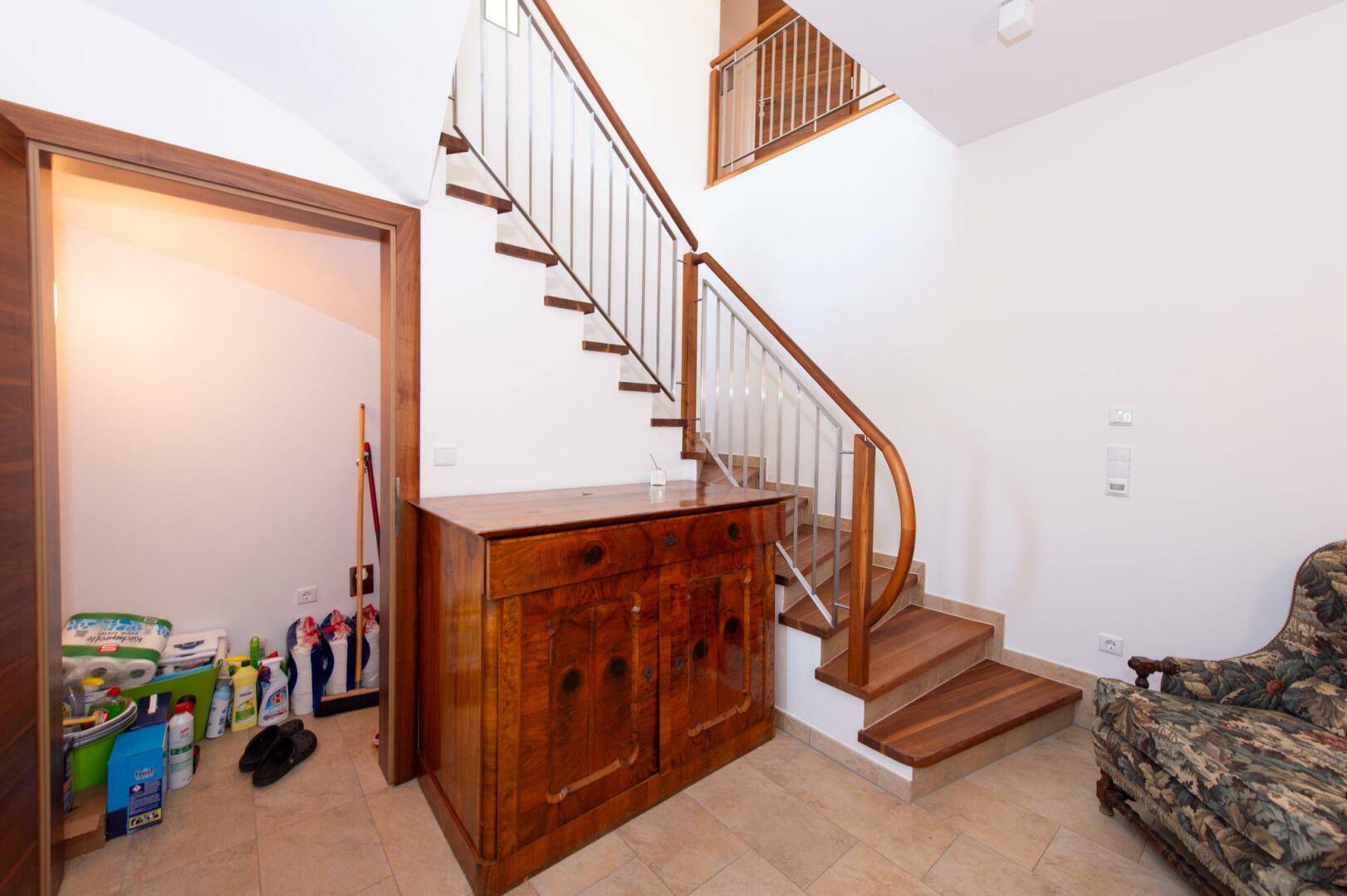 Treppenhaus mit Holzstufen und Metallgeländer, führt in die oberen Etagen.