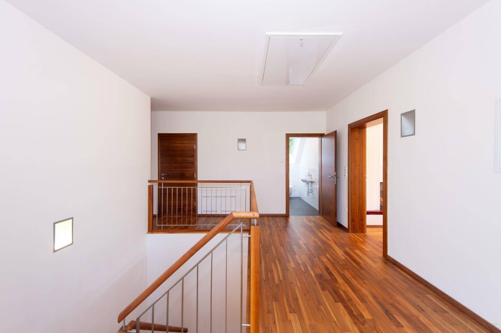 Geräumiger Flur im Dachgeschoss mit Holzboden und Zugang zu weiteren Zimmern.