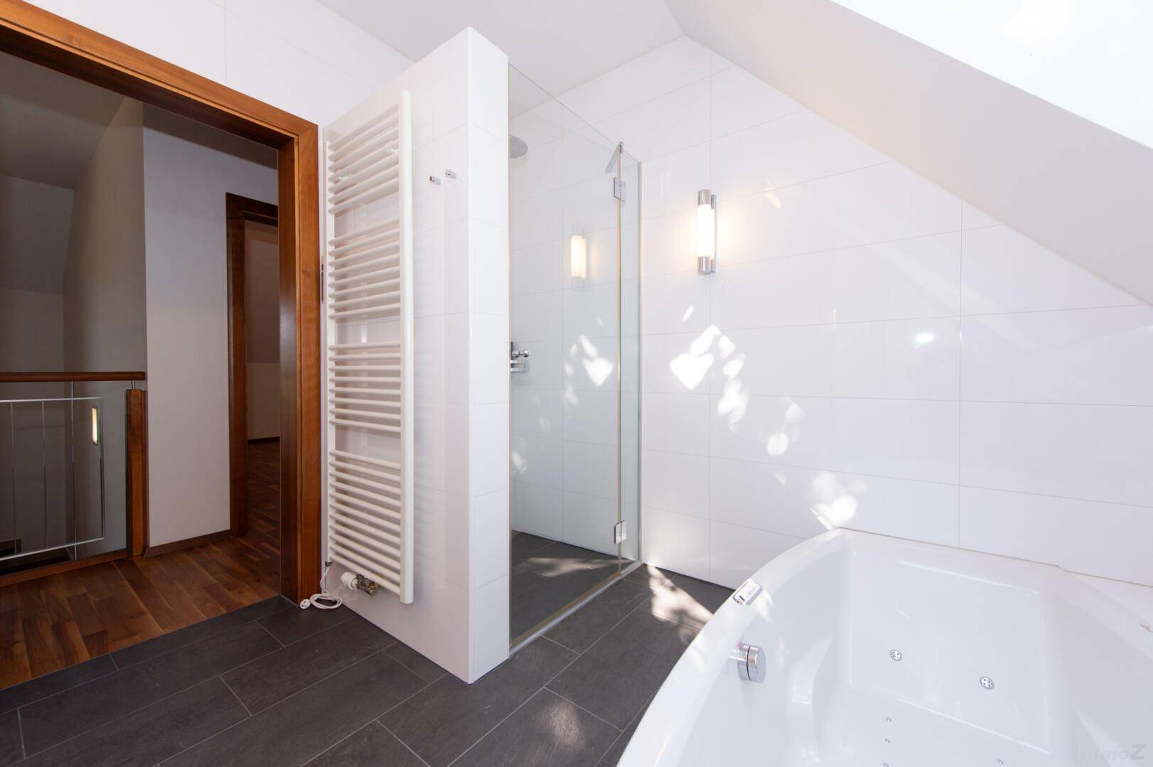 Modernes Badezimmer im Dachgeschoss mit Dusche, Badewanne und beheiztem Handtuchhalter.