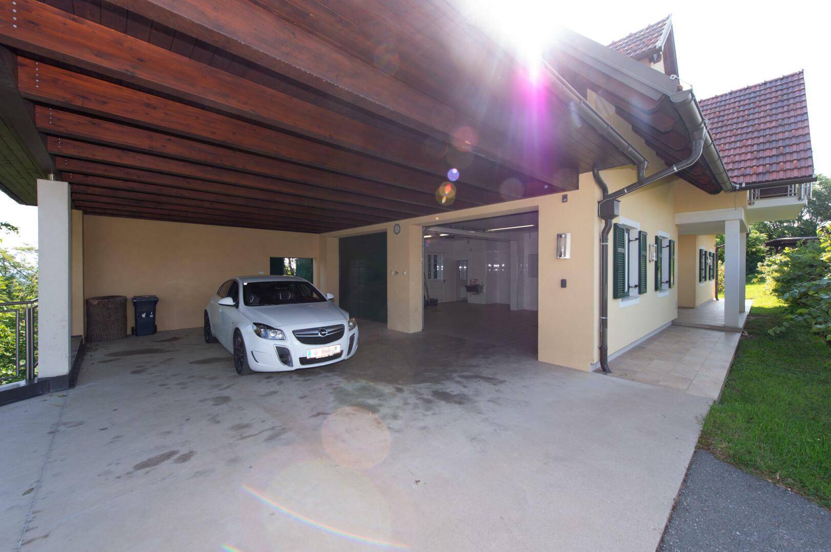Geräumiger Carport und Garageneinfahrt am Haus, mit viel Platz für Fahrzeuge.