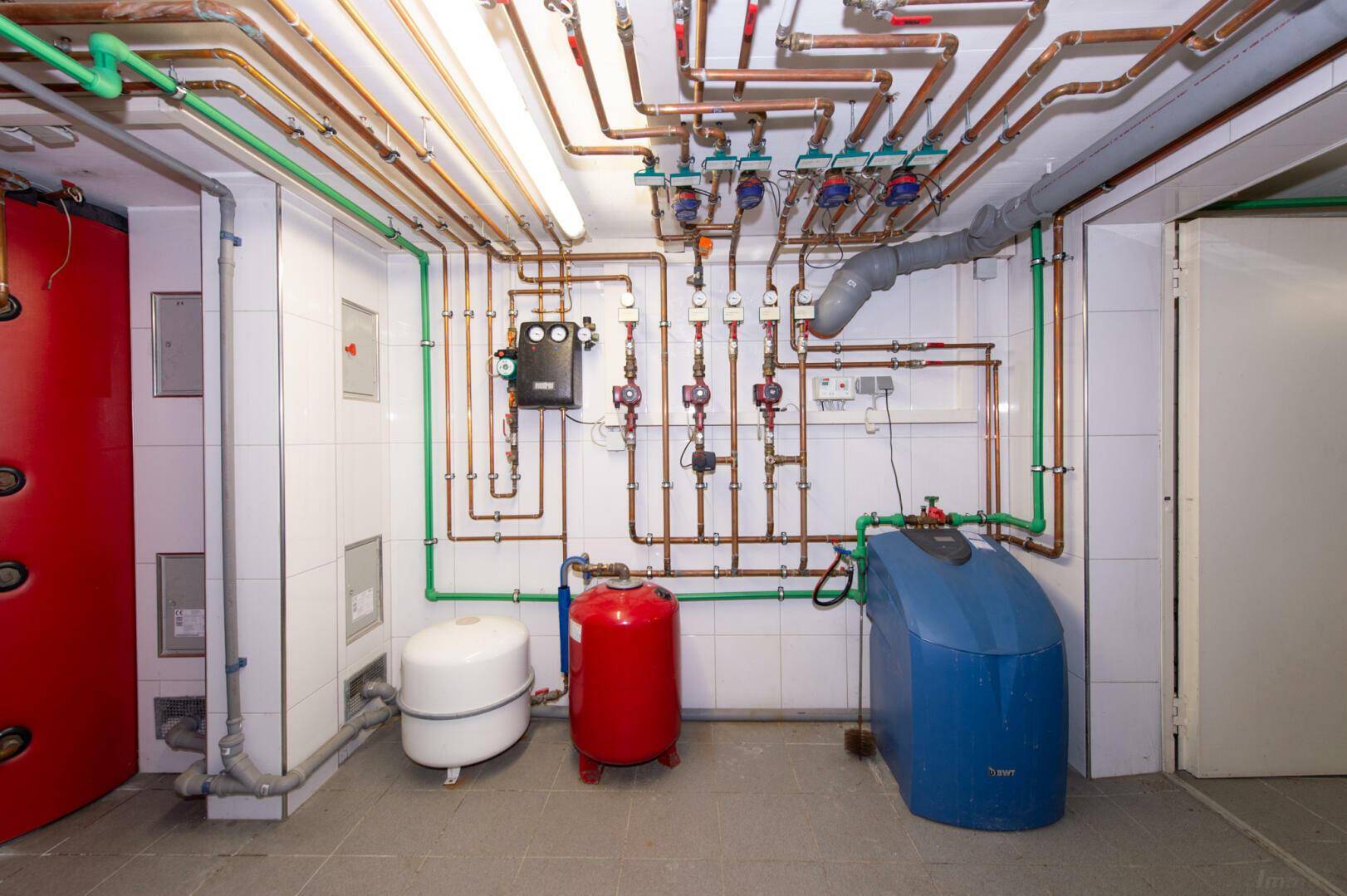 Detailansicht der Heizungsanlage und Rohrleitungen im Keller, gut organisiert.