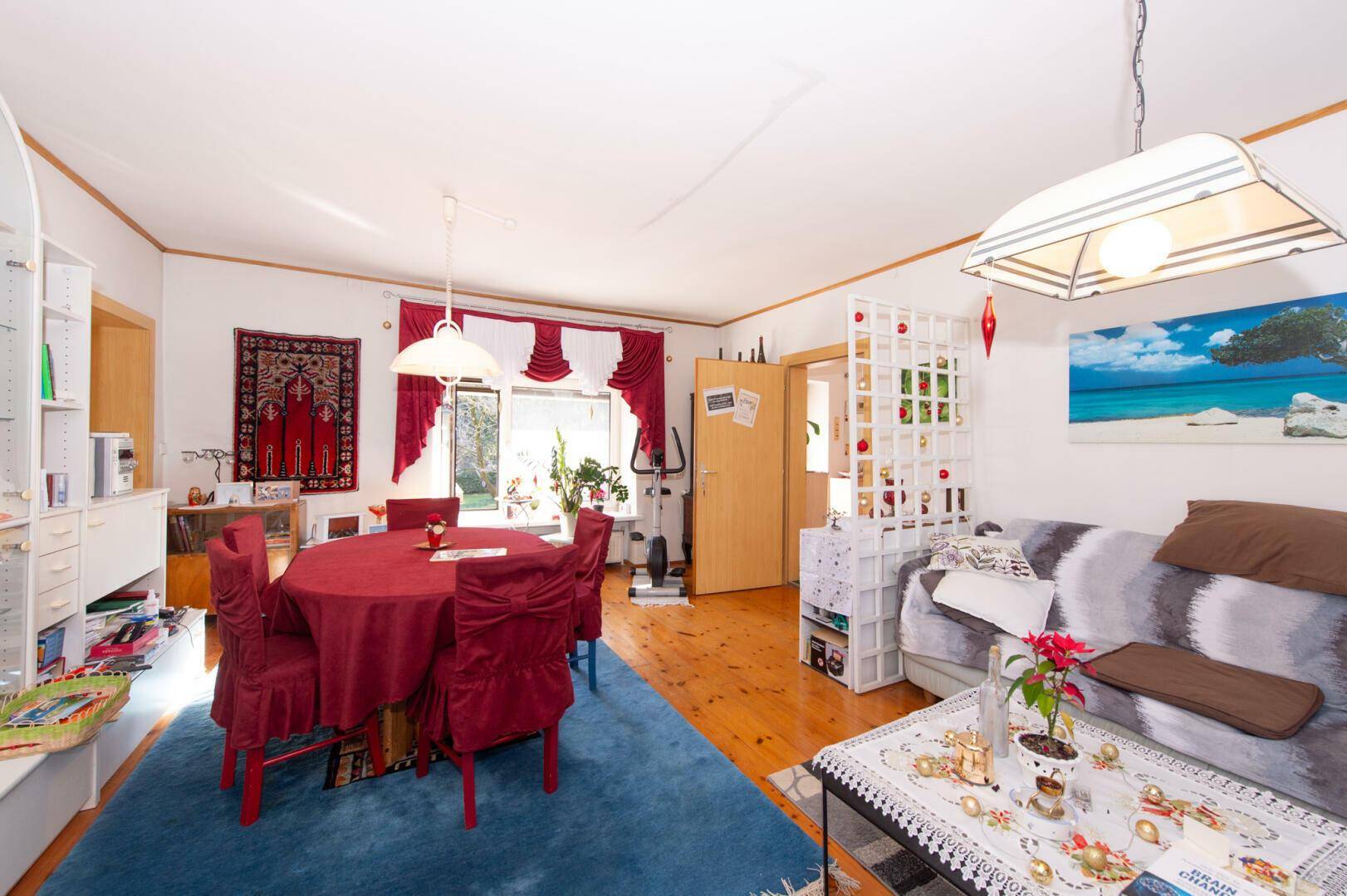 Geräumiger Wohn-Essbereich mit Sofa, Esstisch und Holzboden.