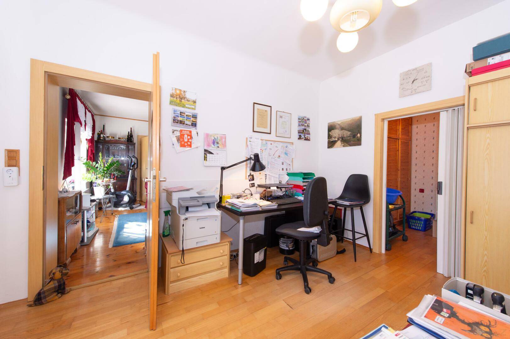 Arbeitszimmer mit Holzboden und Zugang zu weiteren Räumen.