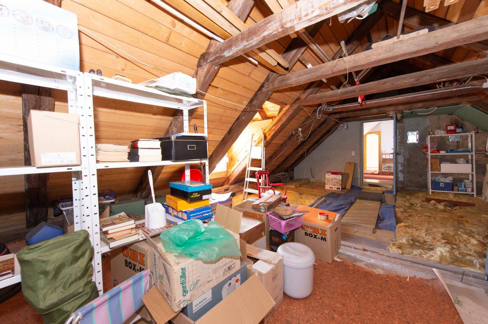 Dachboden als Lagerraum mit Regalen und Holzkonstruktion.