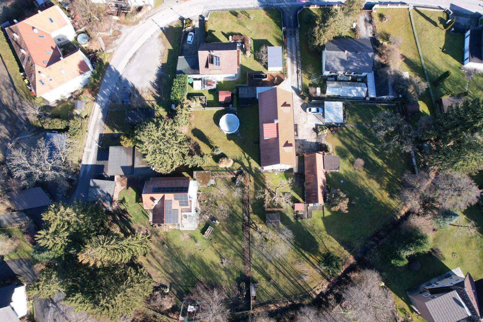 Luftaufnahme des Anwesens mit umliegenden Häusern und viel Grün.