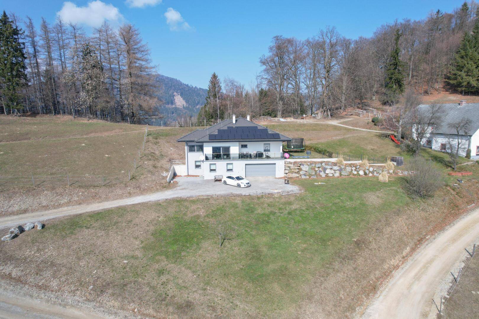 Luftaufnahme des modernen Hauses mit Photovoltaikanlage und Garage.