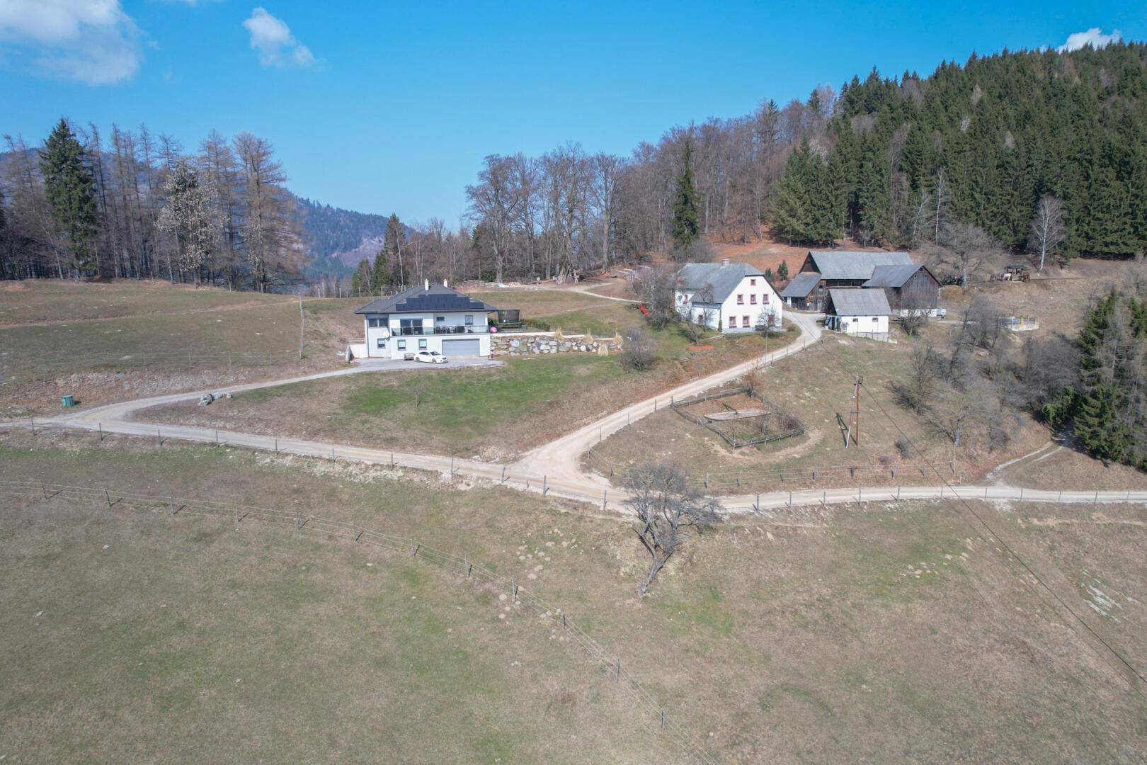 Luftaufnahme der beiden Anwesen in einer idyllischen Berglandschaft.