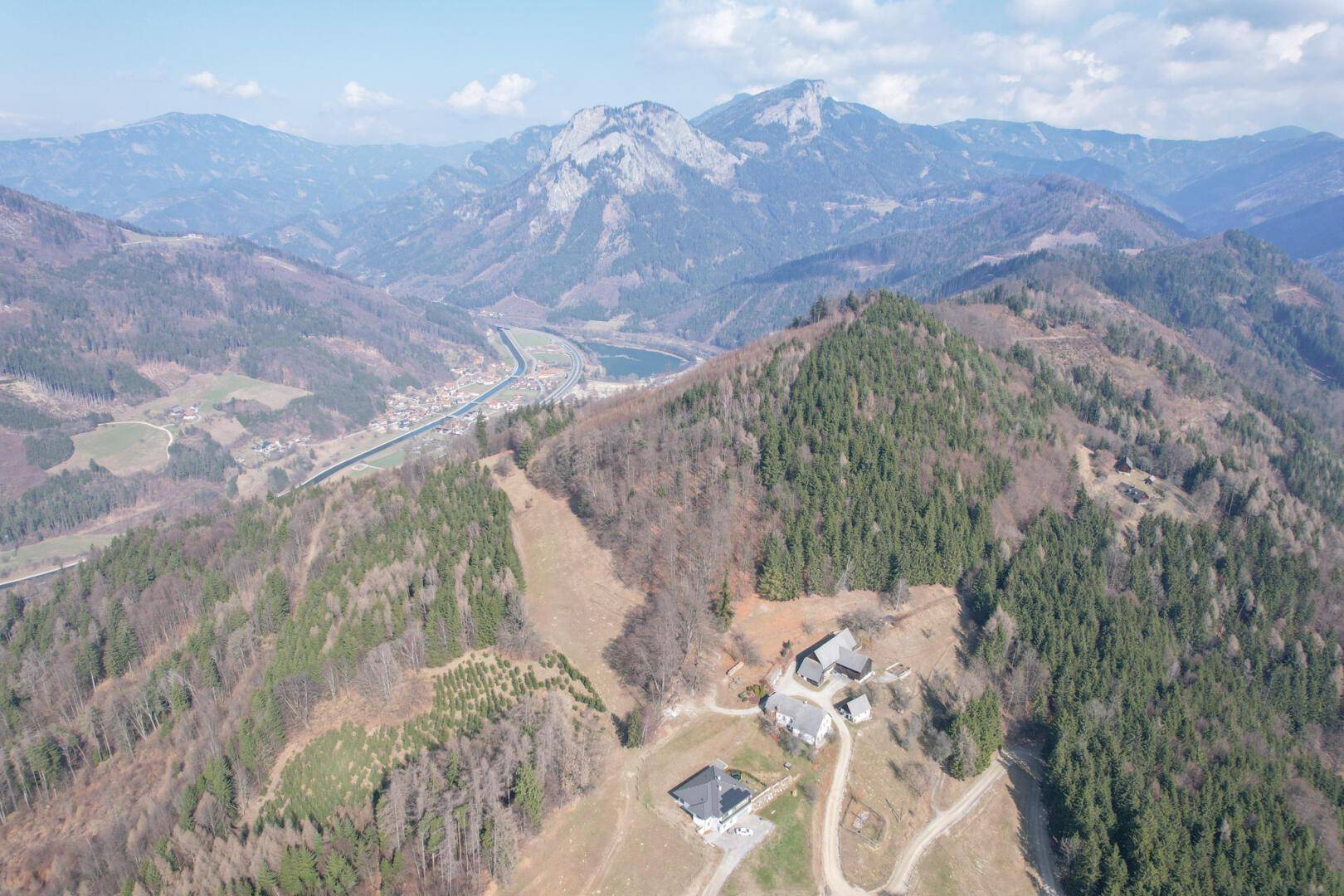 Weitläufige Luftaufnahme der Anwesen mit Blick auf ein Tal und einen See.