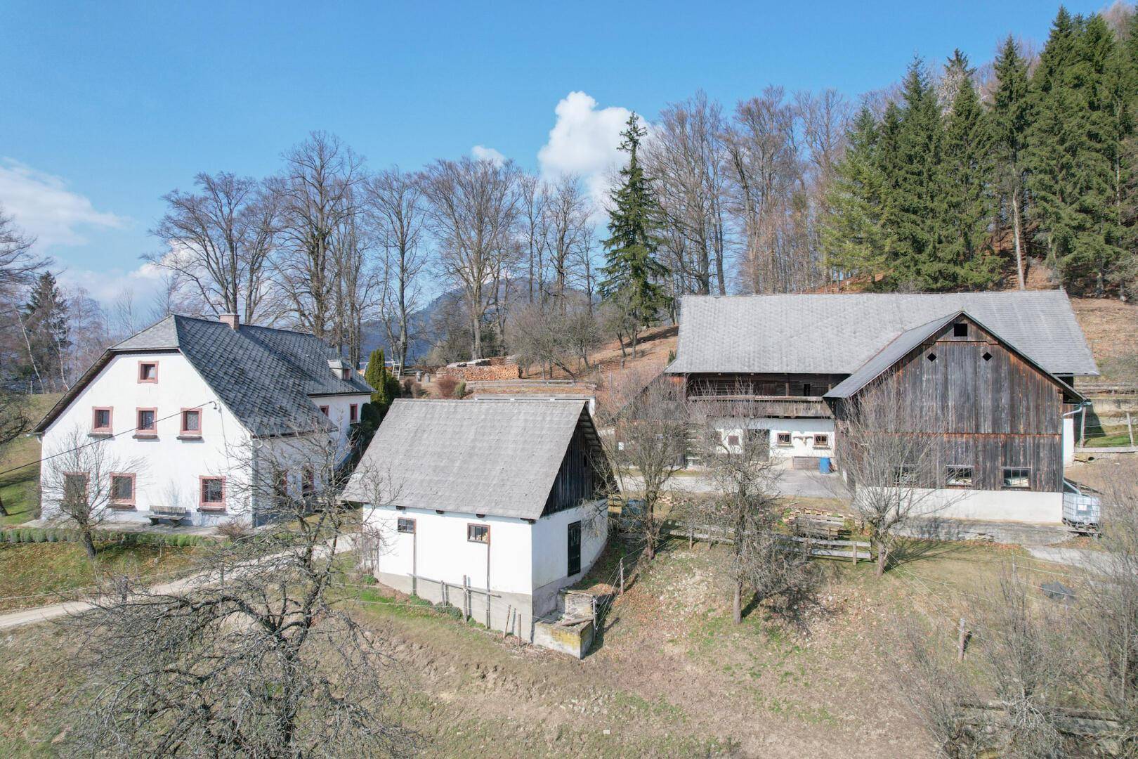 Mehrere traditionelle Gebäude in einer idyllischen, ländlichen Umgebung.