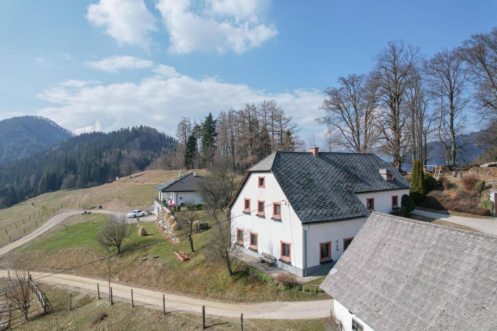 Panoramablick auf die Anwesen in einer weitläufigen, grünen Landschaft.