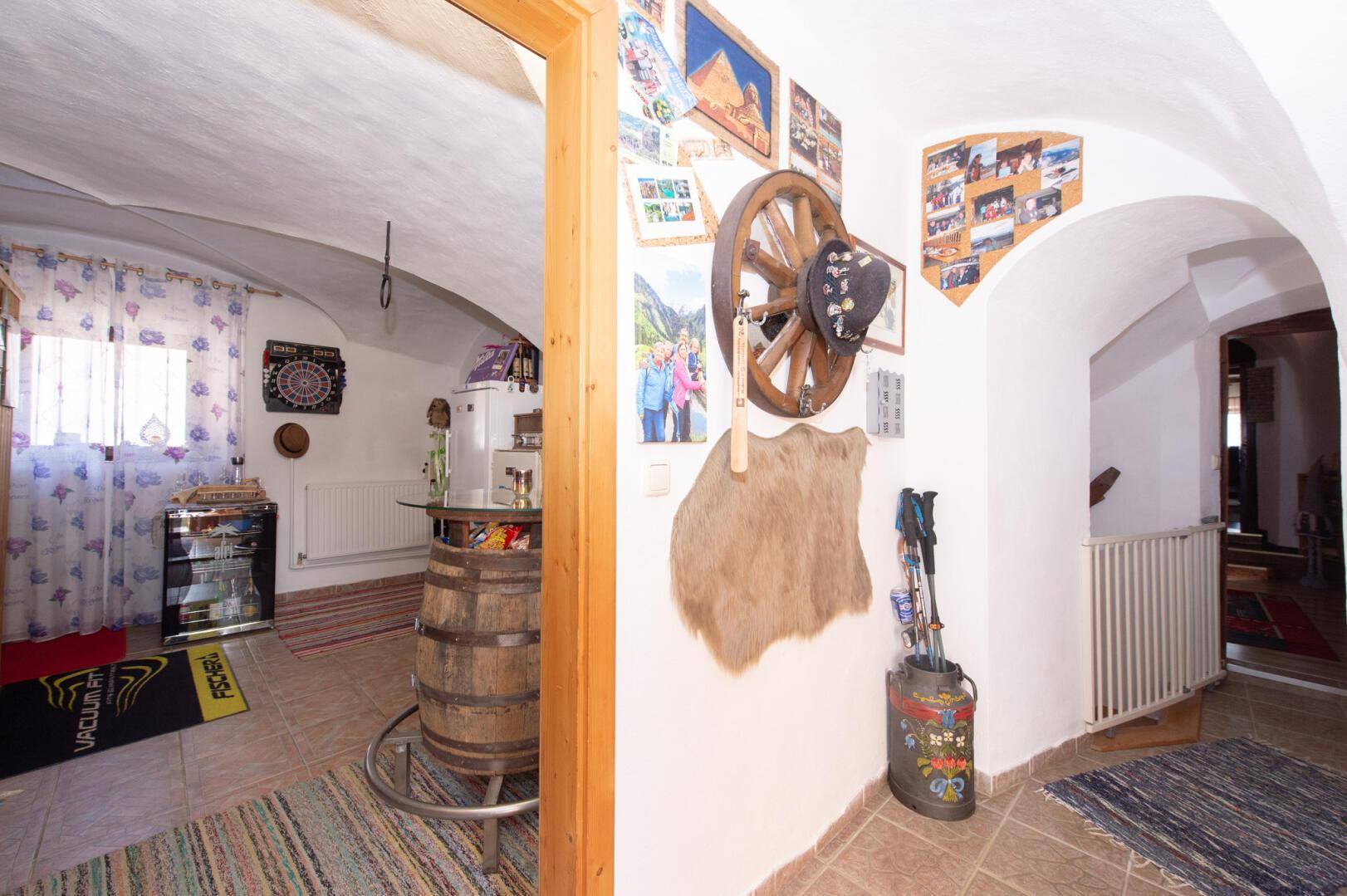 Rustikaler Flur mit Gewölbedecke, Fliesenboden und traditioneller Dekoration.