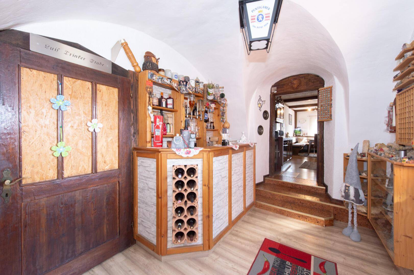 Rustikale Hausbar mit Weinflaschenregal und traditioneller Einrichtung.