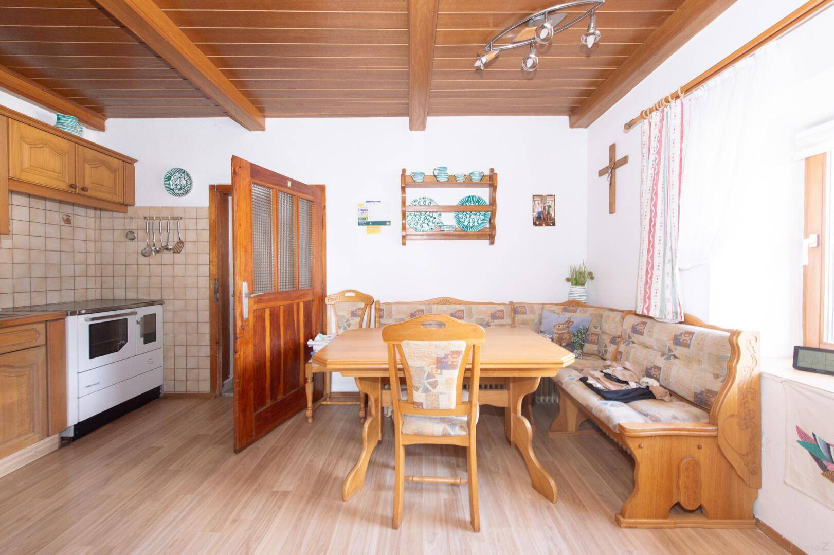 Gemütlicher Essbereich in der traditionellen Küche mit Holztisch und Eckbank.