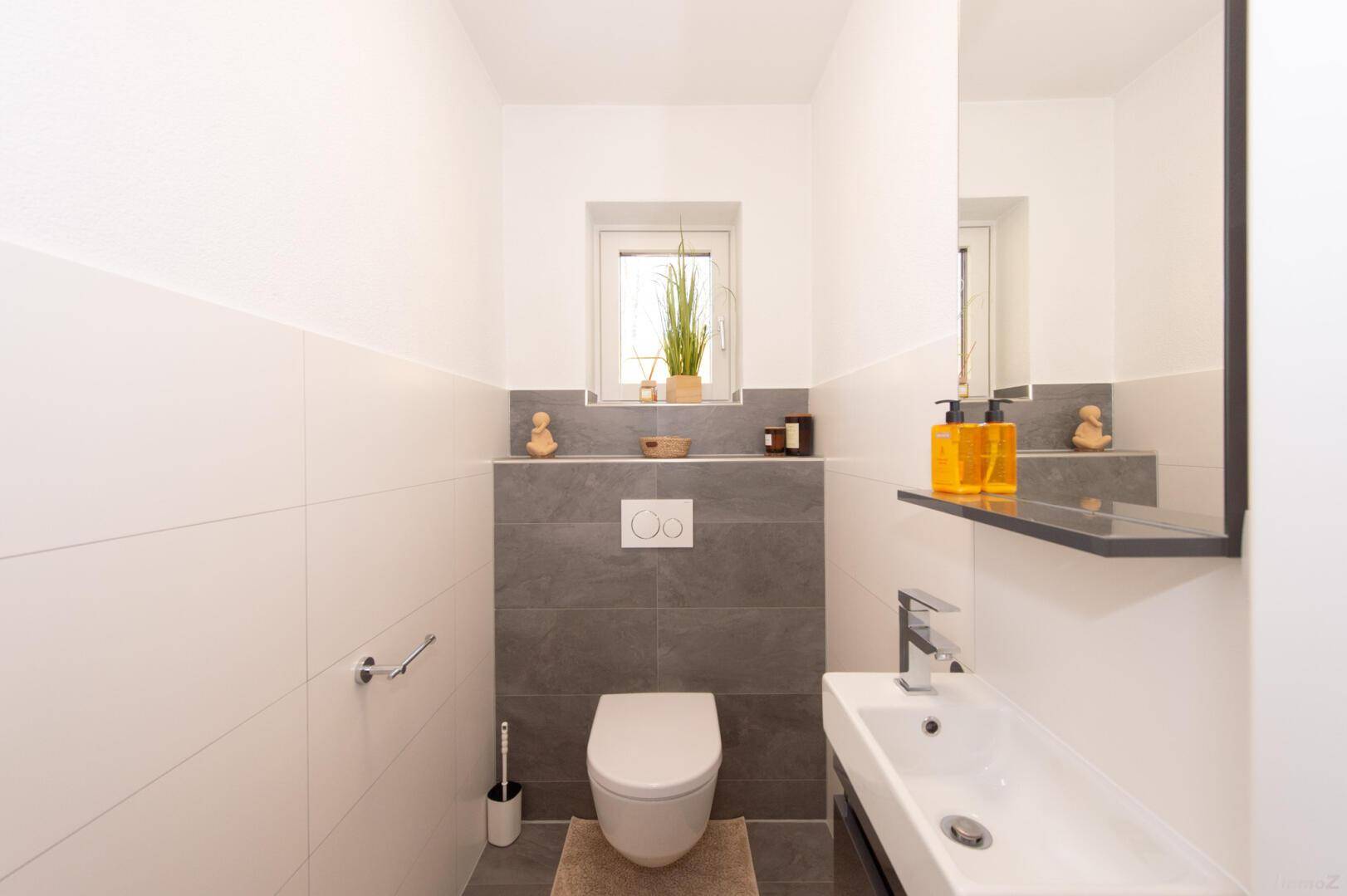 Modernes Gäste-WC mit Wand-WC, kleinem Waschbecken und Fenster.