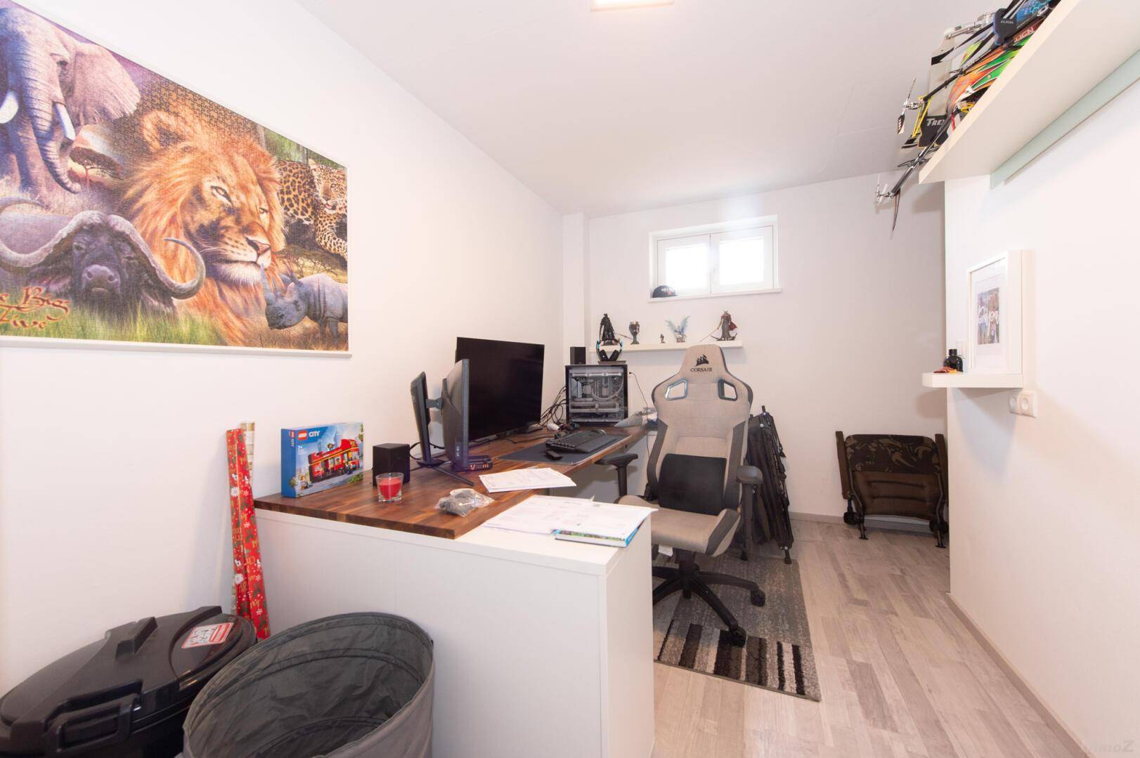 Funktionales Büro mit Schreibtisch, Gaming-Stuhl und Wanddekoration.
