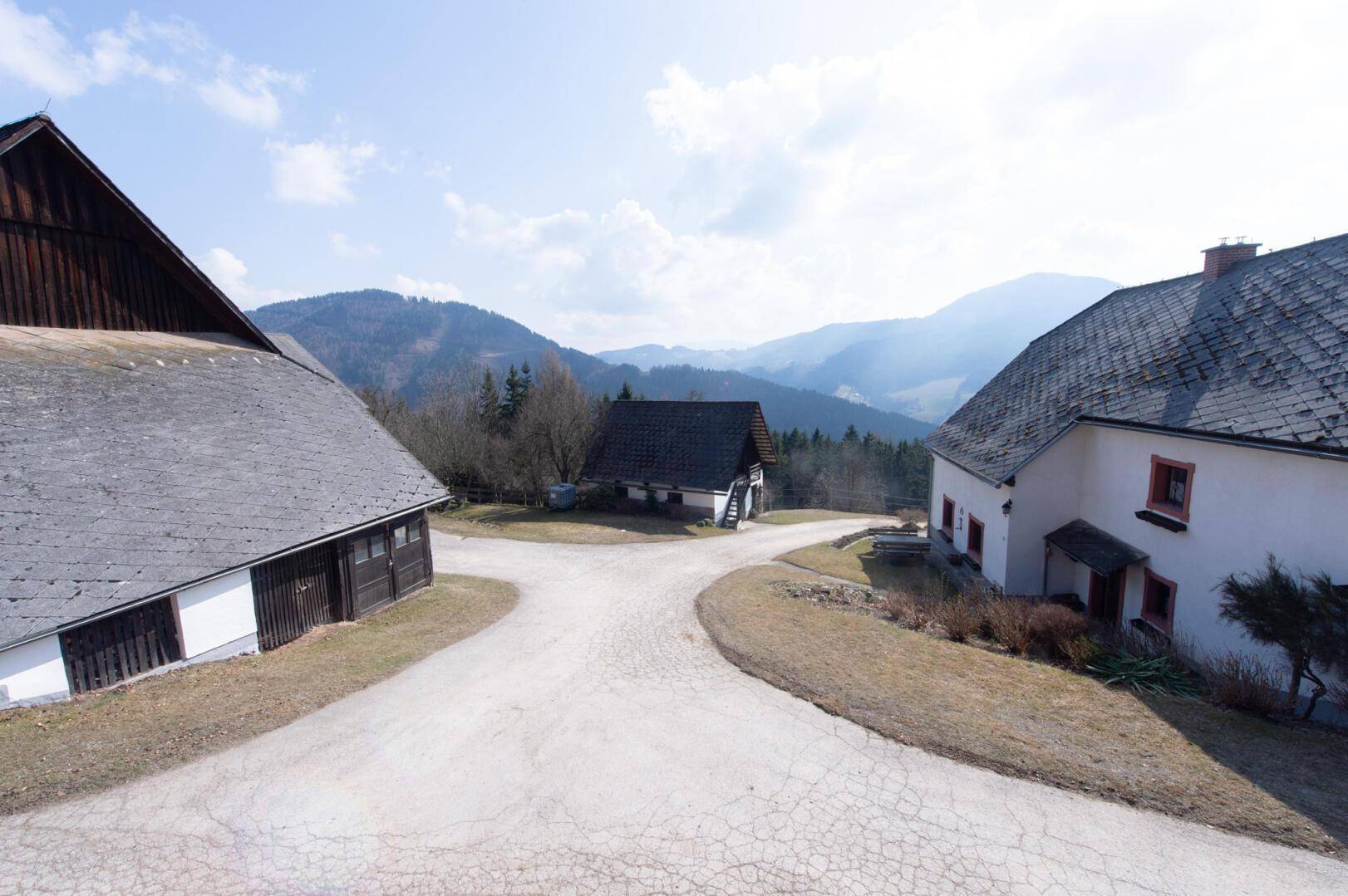 Traditionelle Gebäude mit Schotterweg und Blick auf die umliegende Landschaft.