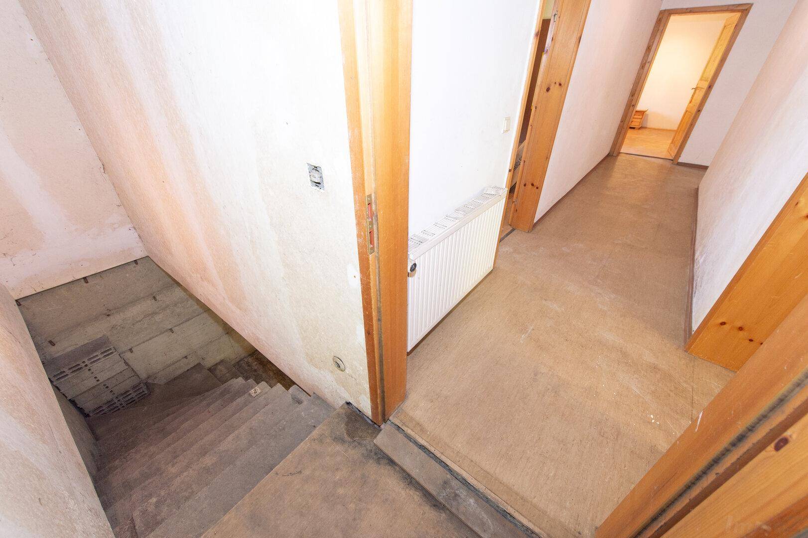 Flur mit Treppe zum Keller und Zugang zu weiteren Räumen.