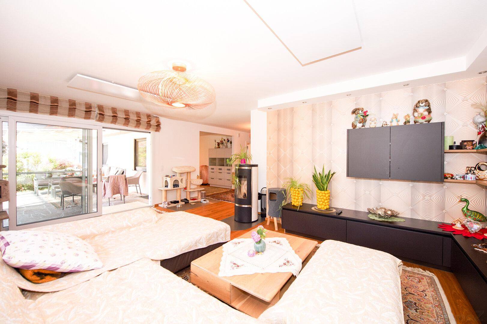 Geräumiger Wohnbereich mit großem Sofa, TV-Möbel und Zugang zu einer sonnigen Terrasse.