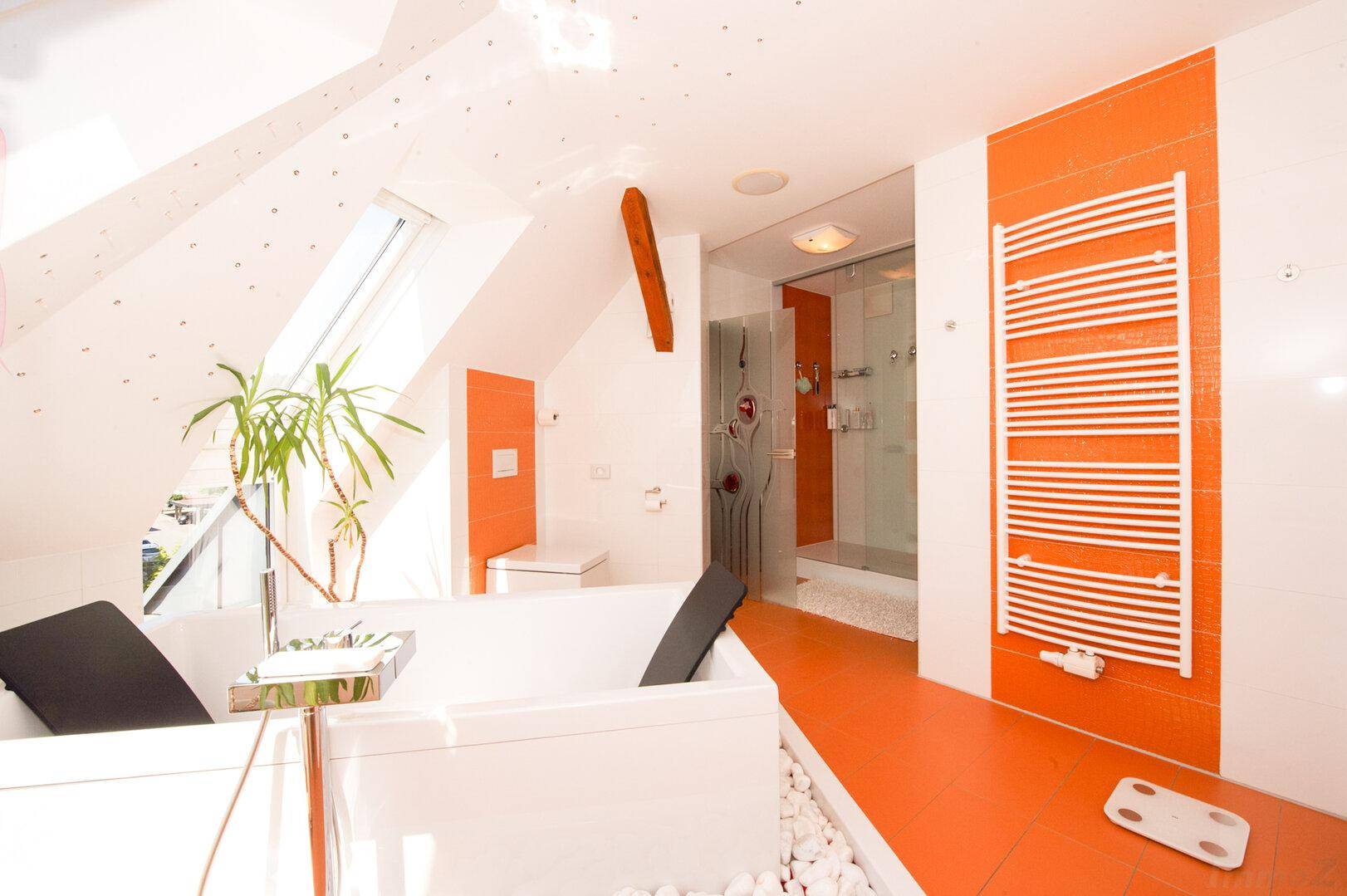 Geräumiges Badezimmer mit Badewanne, Duschkabine und Handtuchheizkörper.