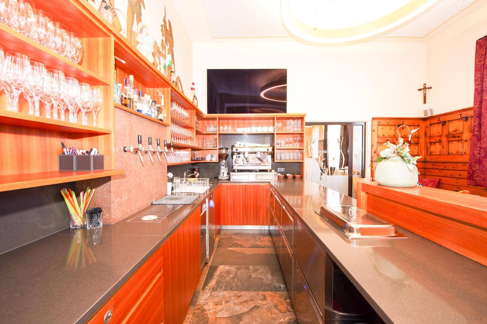 Gut ausgestattete Bar mit Kaffeemaschine, Gläsern und modernen Theken.