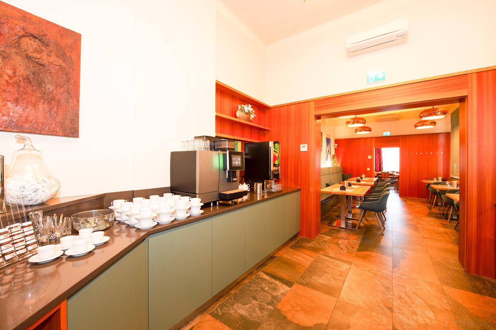 Buffetbereich mit Kaffeemaschinen und Blick in einen weiteren Speisesaal.