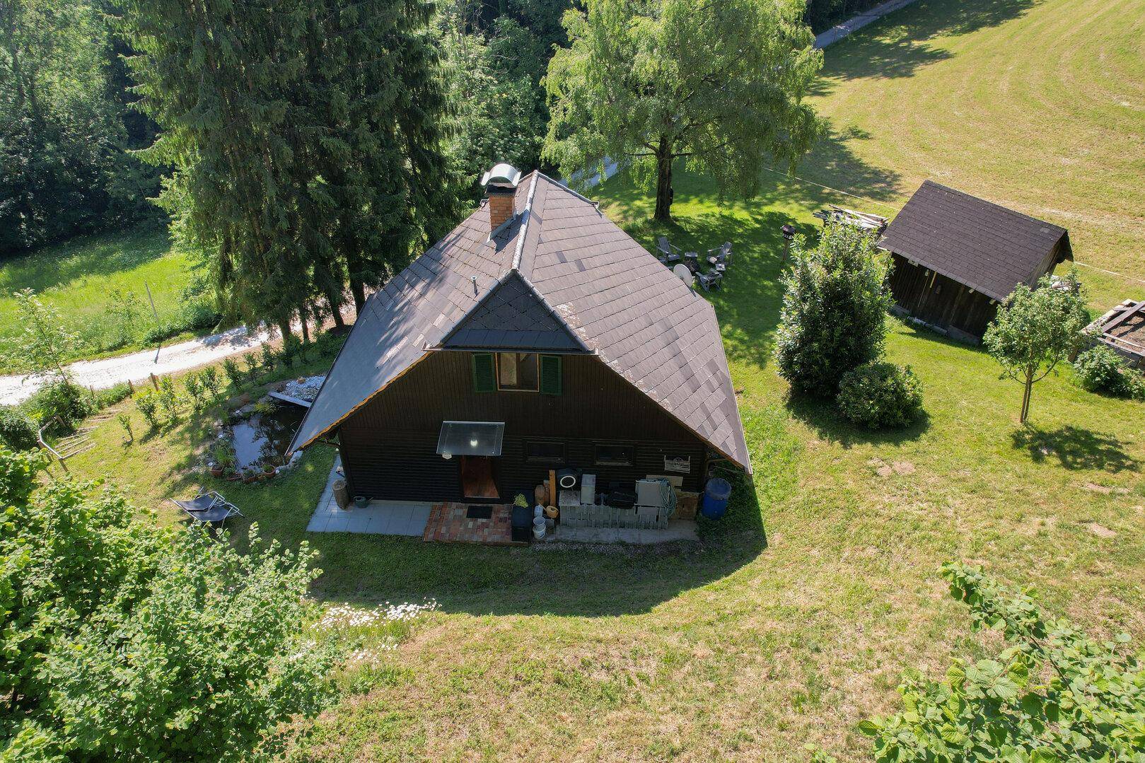 Überblick über das Anwesen mit Haupthaus, Nebengebäude und umgebender Naturlandschaft.