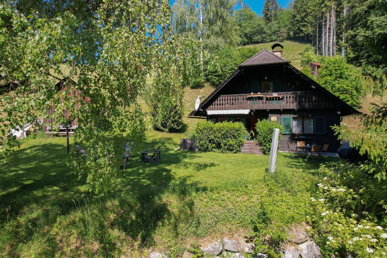 Charmantes Holzhaus in idyllischer Hanglage mit weitläufigem grünen Gartenbereich.