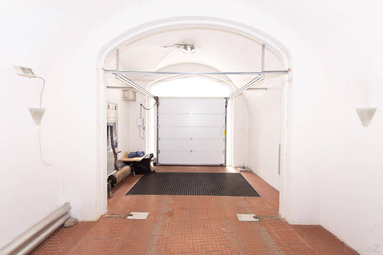 Eingangsbereich einer Garage mit Rolltor und gewölbter Decke, bereit zur Nutzung.