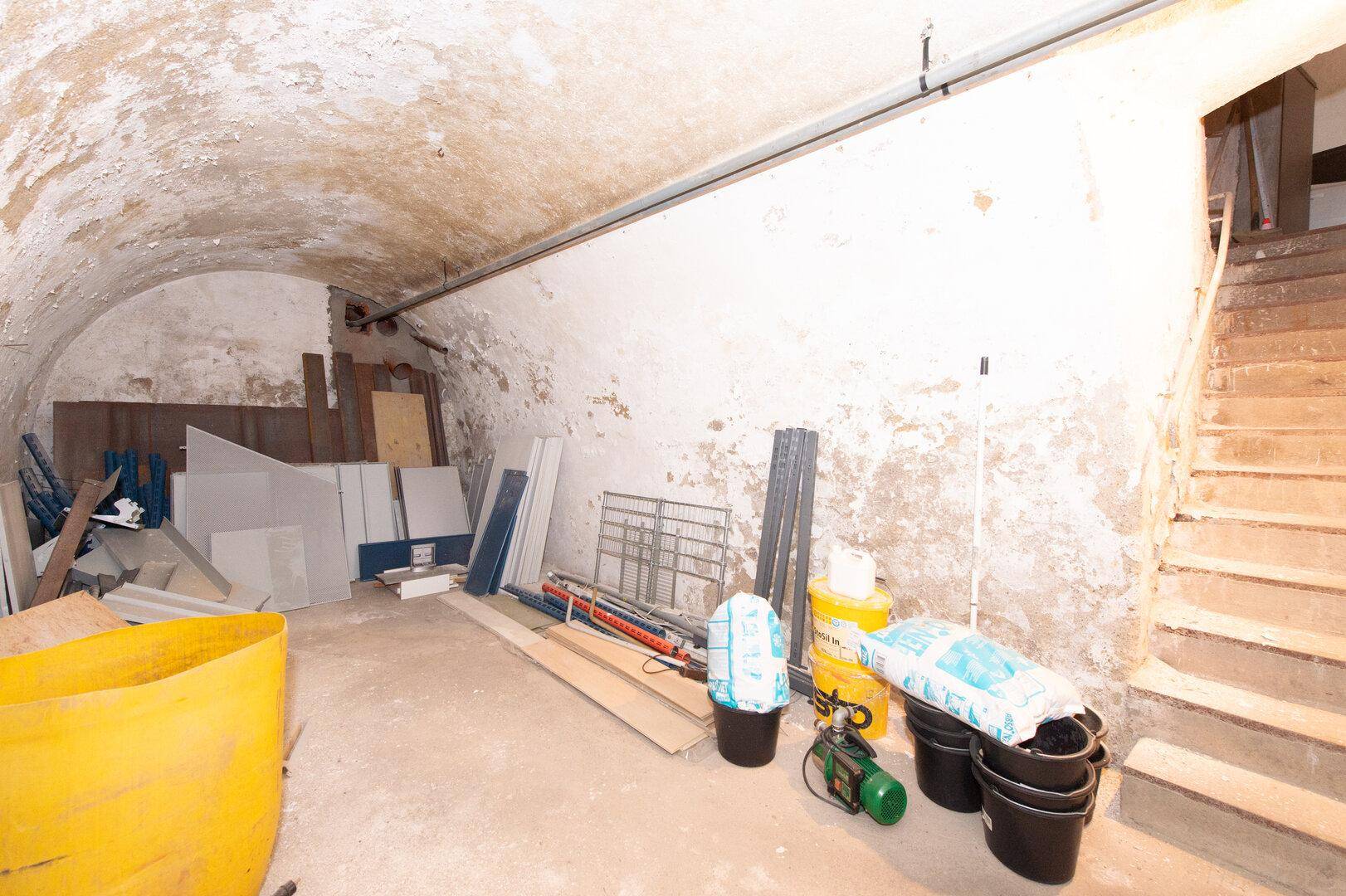 Geräumiger Kellerraum mit gewölbter Decke und viel Stauraum für diverse Gegenstände.