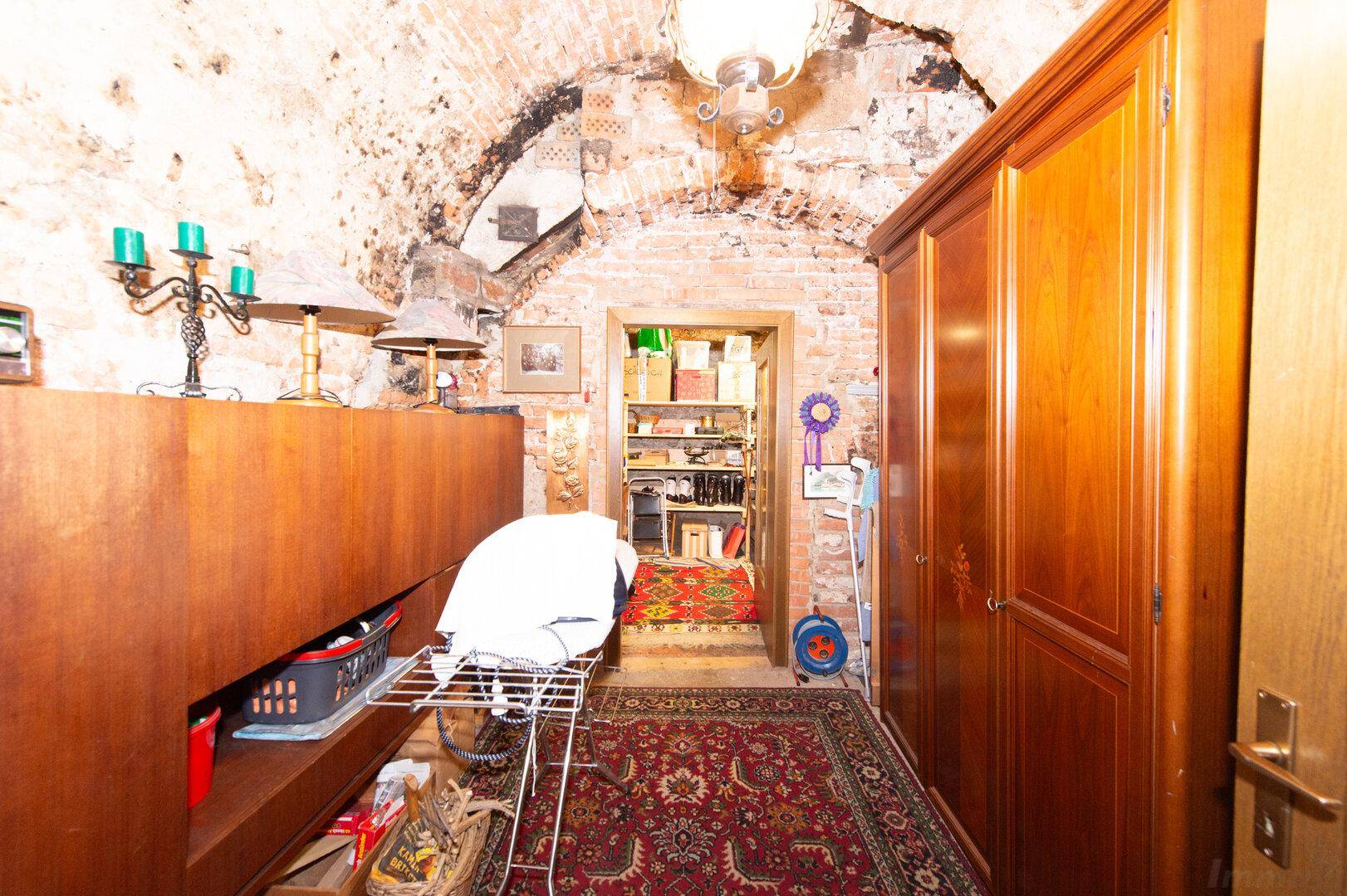Historischer Kellerraum mit unverputzten Ziegelwänden und gewölbter Decke, ideal als Lager.