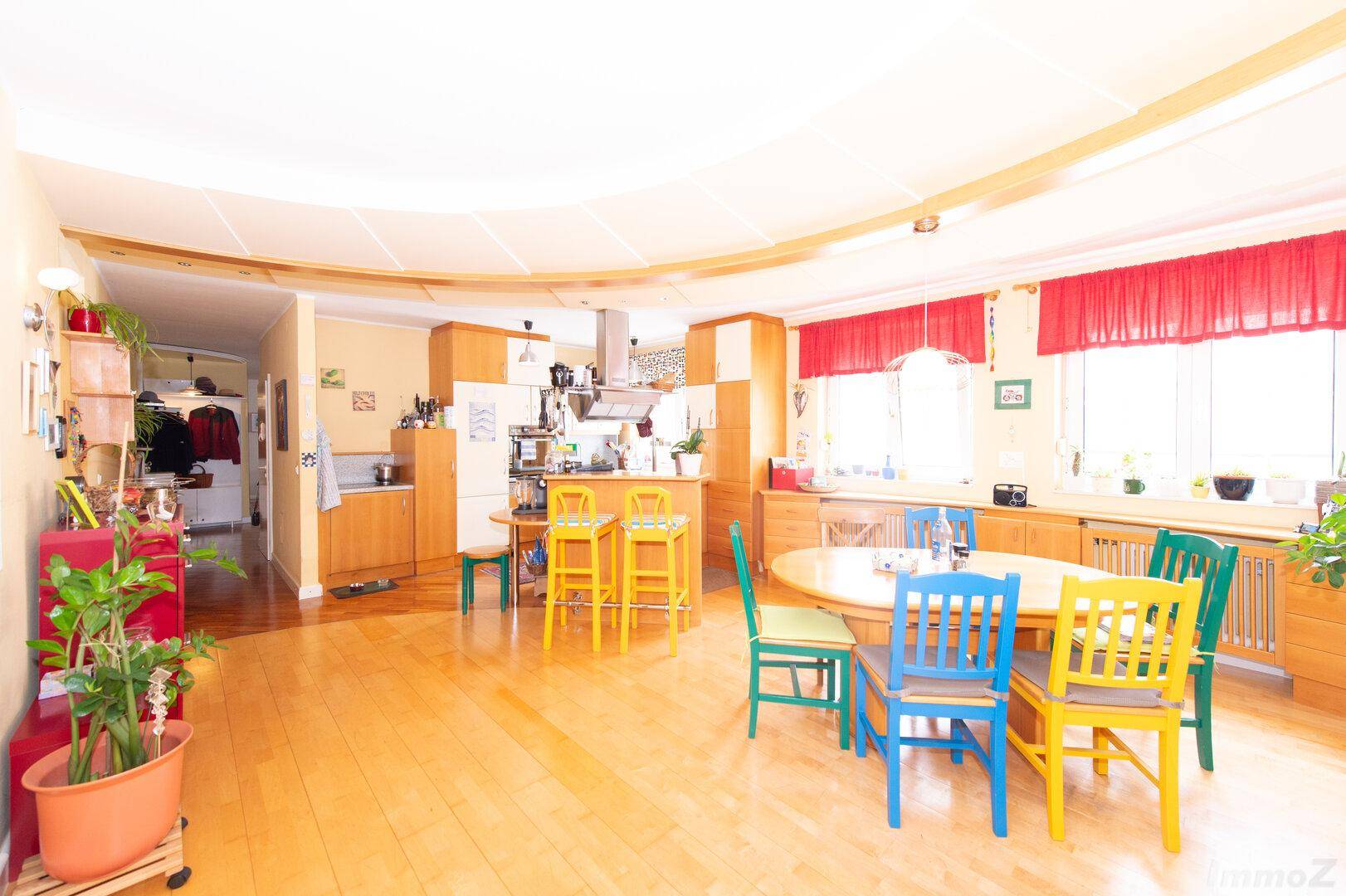 Geräumiger offener Wohnbereich mit Holzboden, Essbereich und Küche, ideal für Familienleben.