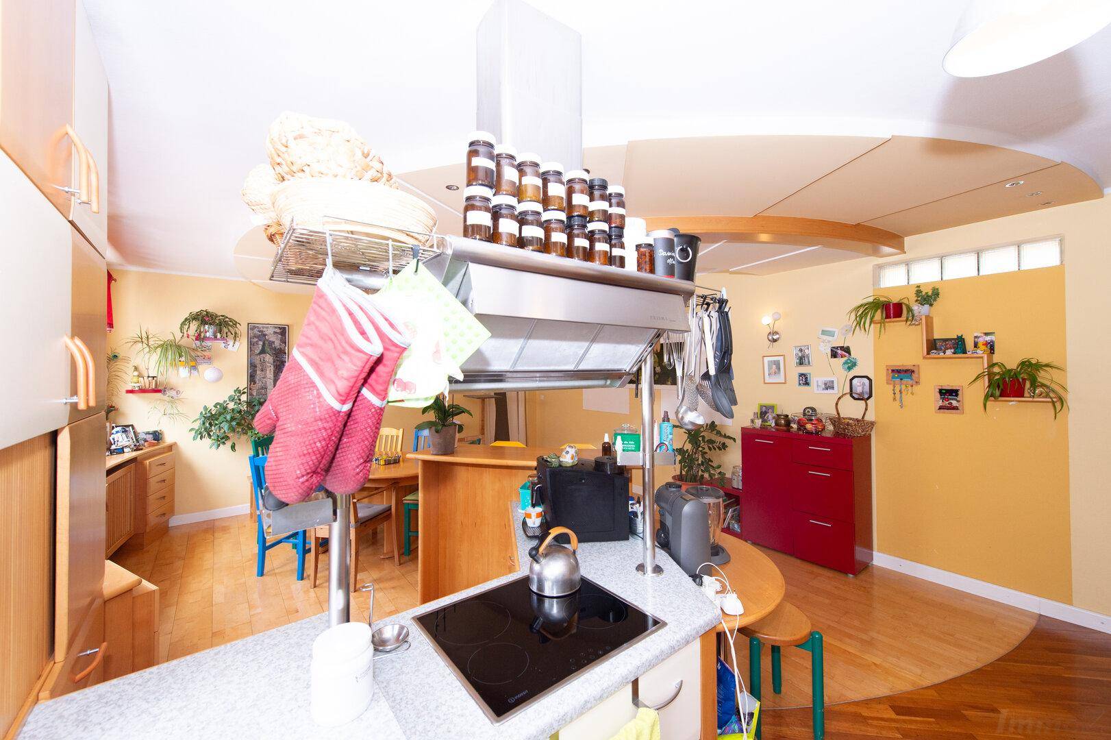 Offene Küche mit Kochinsel, Induktionskochfeld und viel Stauraum, ideal für geselliges Kochen.